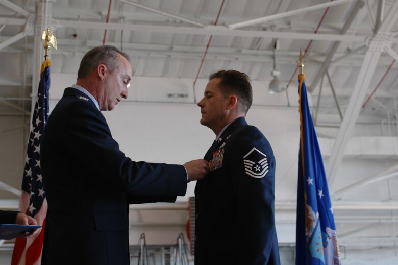 Col. Ed Walker, 917th Wing commander, pins the Bronze Star medal on Master Sgt. Kyle Waller, 917th Explosive Ordnance Disposal Flight technician Sunday, Oct. 14, at the quarterly Wing commander's call in the A-10 hangar, Barksdale AFB, La. (U.S. Air Force photo/Staff Sgt. Ebony Nichols)
