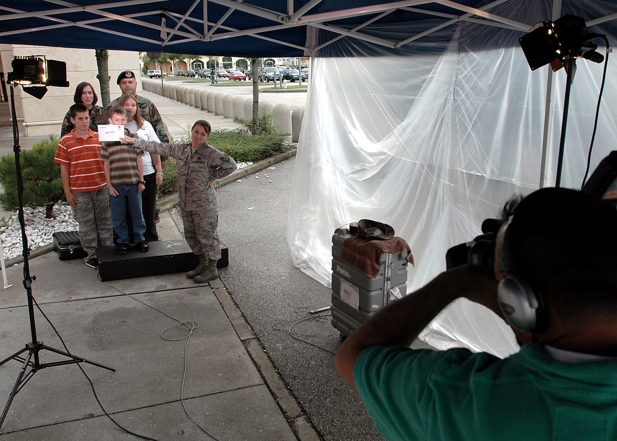 Tech. Sgt. Michele Thomas holds up slate during the taping of a holiday greeting by the Wright family at Aviano Air Base, Italy, for family and friends back in the U.S.  An Army and Air Force Hometown News "Greets" team was at Aviano to film family holiday greetings destined for commercial television stations back home.  Sergeant Thomas is a member of the "Greets" team.  (U.S. Air Force photo/Tech. Sgt. Michael O'Connor)