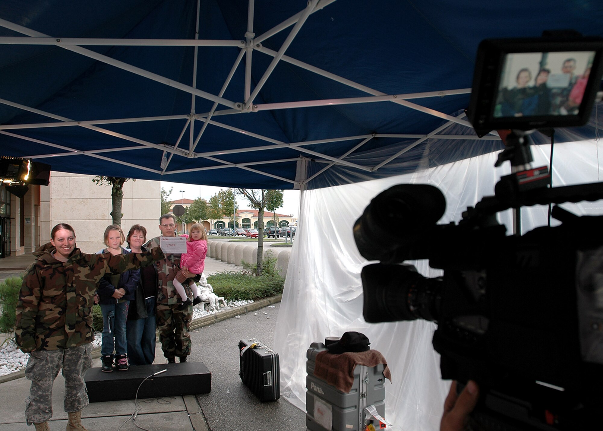 Army Pfc Samantha Ciaramitaro holds up slate during the taping of a holiday greeting by the Stark family at Aviano Air Base, Italy, for family and friends back in the U.S.  An Army and Air Force Hometown News "Greets" team was at Aviano to film family holiday greetings destined for commercial television stations back home.  Private Ciaramitaro is a member of the "Greets" team.  (U.S. Air Force photo/Tech. Sgt. Michael O'Connor)