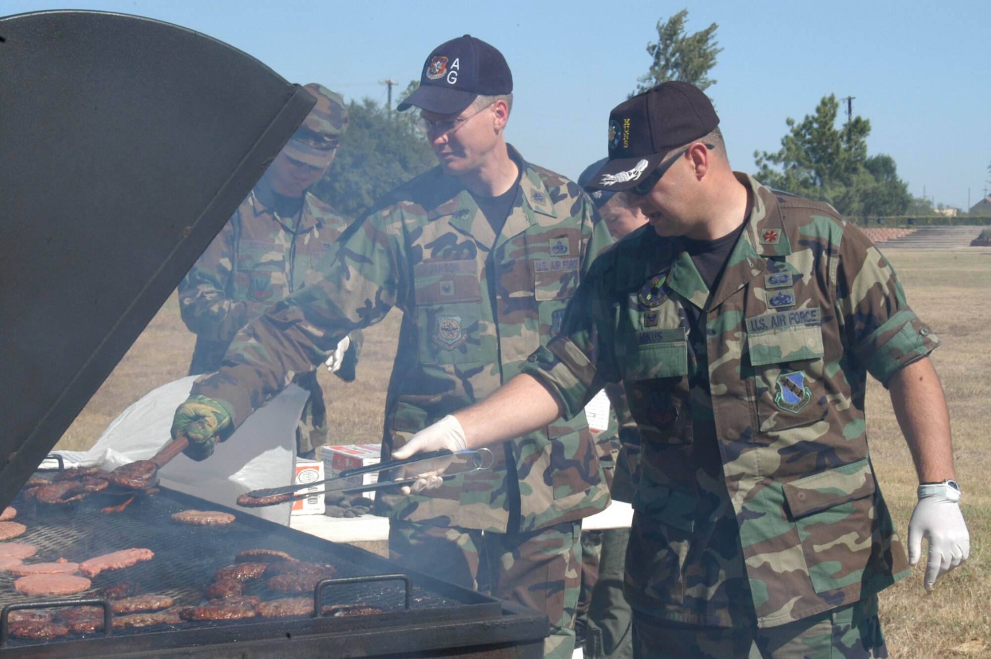 (Right to left): Major Brian Mikus, 7th Munitions Squadron commander, and Lt. Col. Clarence Janson, 317th Airlift Group, cook out at the annual Combined Federal Campaign burger burn Oct. 18 at the parade grounds. The burger burn this year raised more than $20,000 for local and global charities. (U.S. Air Force photo by Senior Airman Carolyn Viss)                                