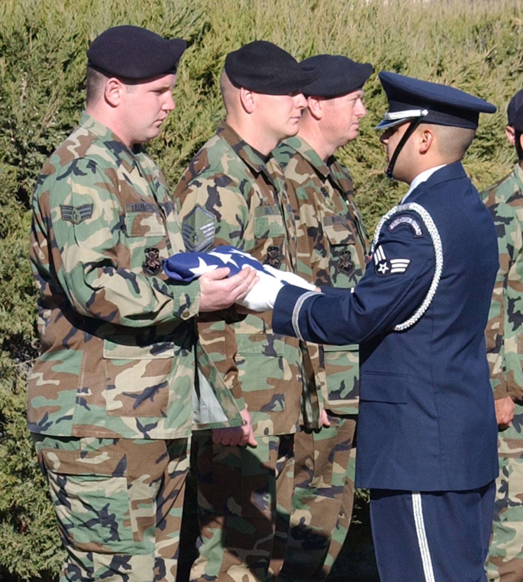 Senior Airman Bryan Tarantella accepts the honorary memorial service flag from Senior Airman Rudy Roland, Malmstrom Honor Guard member, during a memorial Oct. 26 for military working dog Brenda who was euthanized Oct. 17 due to cancerous tumors in her respiratory system. Airman Tarantella was Brenda’s final military working dog handler. (U.S. Air Force photo/Airman 1st Class Dillon White)                               