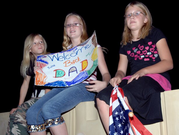 Left to right, Taylor Fetsch, Mara Monroe and Brianna Kolicius wait for Mara's father, Master Sgt. Roylyn Monroe, mechanical superintendant with the 820th RED HORSE Squadron, to return from a deployment Oct. 28. (Air Force photo by Airman 1st Class Brian Ybarbo)
