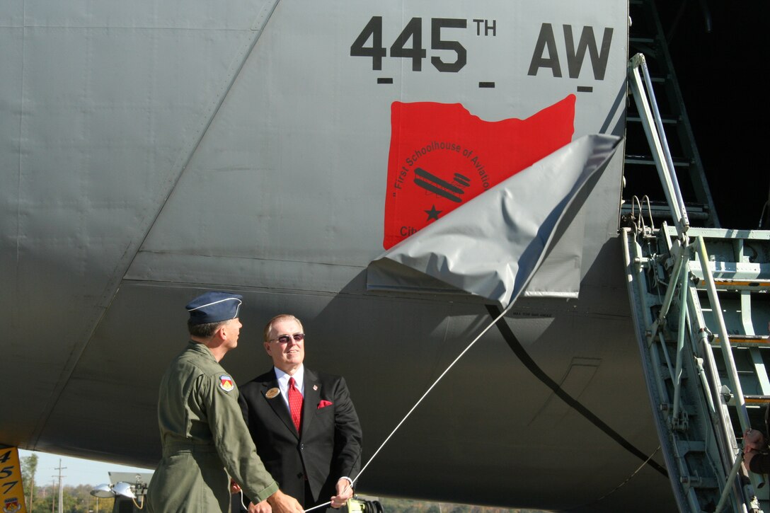 WRIGHT-PATTERSON AFB, Ohio - Brig. Gen. Bruce E. Davis, 445th Airlift Wing commander, and Thomas H. Nagel, Mayor of the City of Fairborn, unveil the nose art on the C-5 during a ceremony to dedicate the aircraft "City of Fairborn - First Schoolhouse of Aviation". (U.S. Air Force photo/Senior Airman Ken LaRock) 