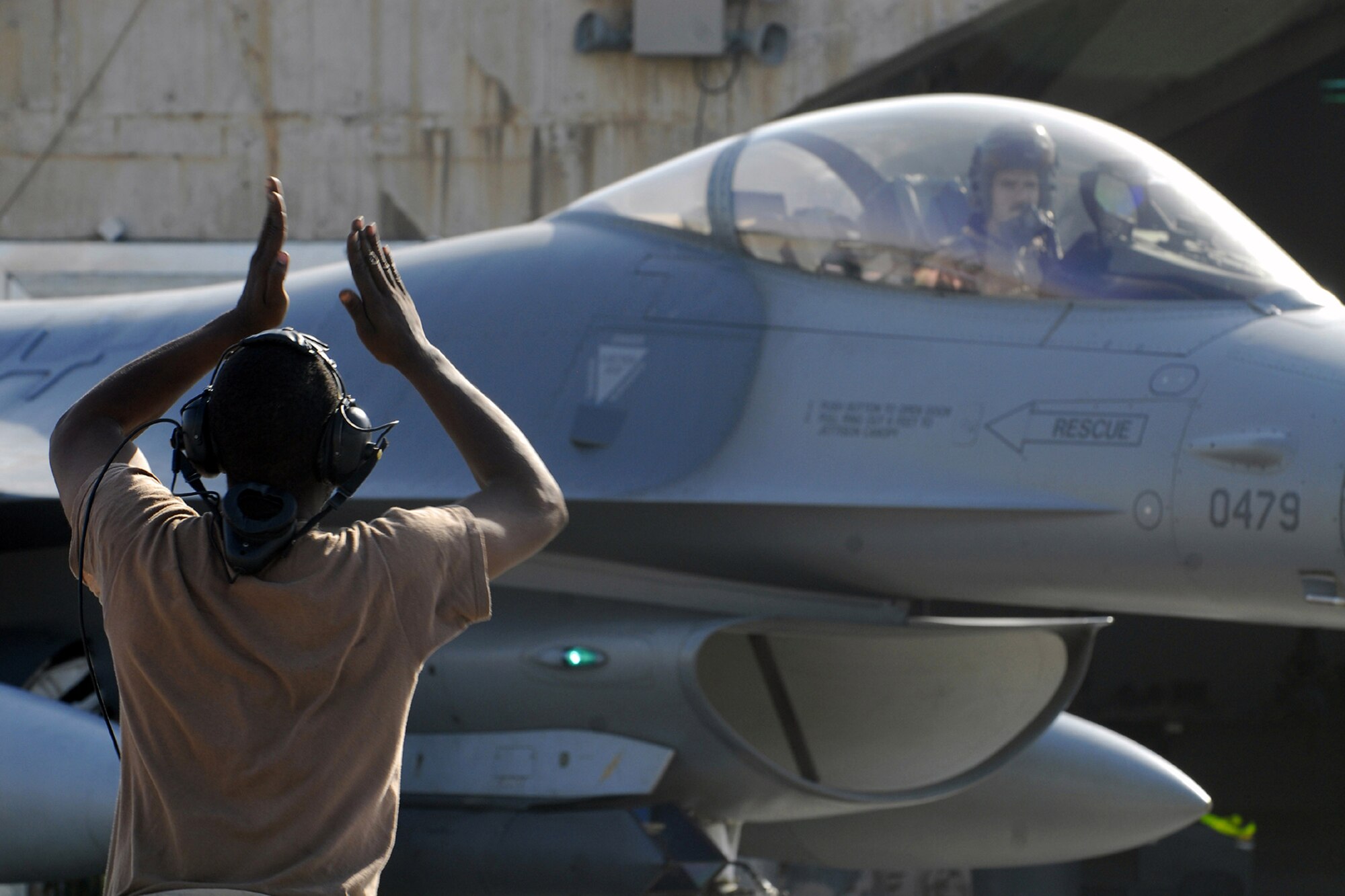 Airman 1st Class Martin Johnson, 332nd Expeditionary Aircraft Maintenance Squadron crew chief, marshals Capt. Thomas Graham, 4th Expeditionary Fighter Squadron, to the flightline at Balad Air Base. Graham and Johnson are deployed from Hill Air Force Base, Utah. (U.S. Air Force photo/Staff Sgt. Joshua Garcia) 
