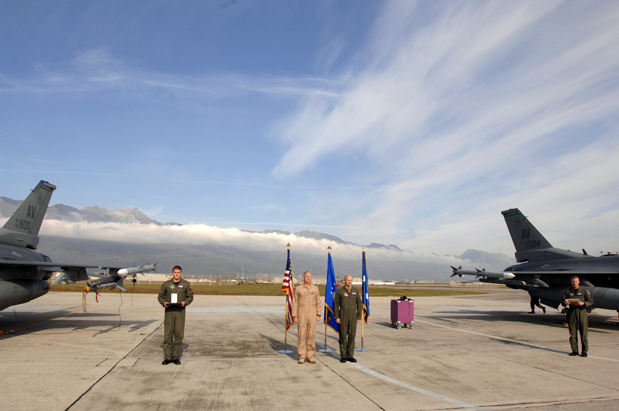 Capt. George Collings and his father and fellow F-16 pilot Maj. Gen. Michael Collings, the senior U.S. defense representative to Egypt, stand at attention during a Distinguished Flying Cross ceremony on the flightline Oct. 29.  General Collings flew into Aviano Air Base, Italy, to present Capt. Collings with the medal for distinguishing himself by extraordinary achievement while participating in aerial flight as an F-16 pilot with the 510th Expeditionary Fighter Squadron based out of Balad Air Base, Iraq. (U.S. Air Force photo/Senior Airman Patrick Dixon) 