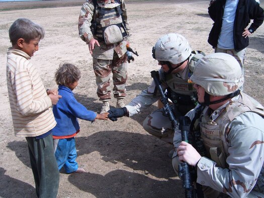 Master Sgt. Paul Tranetzke, 341st Missile Security Forces Squadron operations superintendent, greets an Iraqi child in Arabic during a walking patrol at a local village. Sergeant Tranetzke received the Bronze Star Oct. 25 for his efforts during Operation Iraqi Freedom April 2006 to 2007. (U.S. Air Force photo)