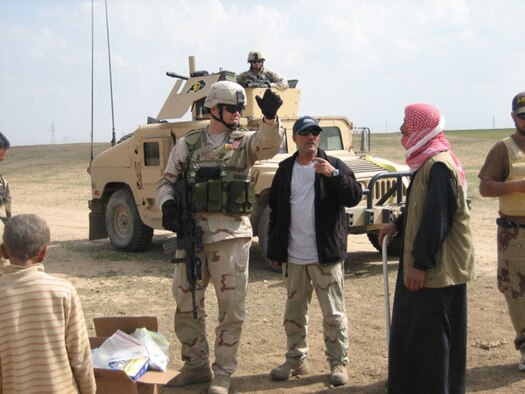 Master Sgt. Paul Tranetzke, 341st Missile Security Forces Squadron operations superintendent, talks with an Iraqi man through his interpreter, "Edward" during a visit to the village to deliver shoes and blankets. Sergeant Tranetzke received the Bronze Star Medal Oct. 25 for his efforts during Operation Iraqi Freedom April 2006 to 2007. (U.S. Air Force photo) 
