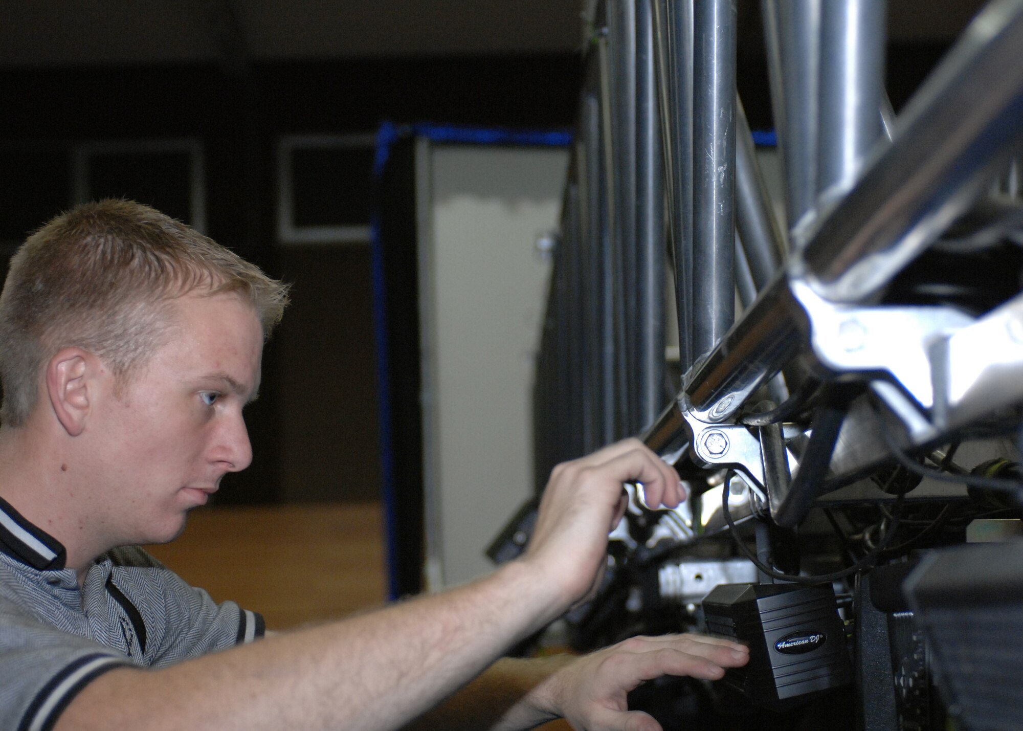 SPANGDAHLEM AIR BASE, Germany -- Senior Airman Jeremiah Smith, from the Air Force performance group Tops In Blue, prepares a lighting system prior to the teams performance at Skelton Memorial Fitness Center Oct. 29. (U.S. Air Force photo/Airman 1st Class Jenifer Calhoun)