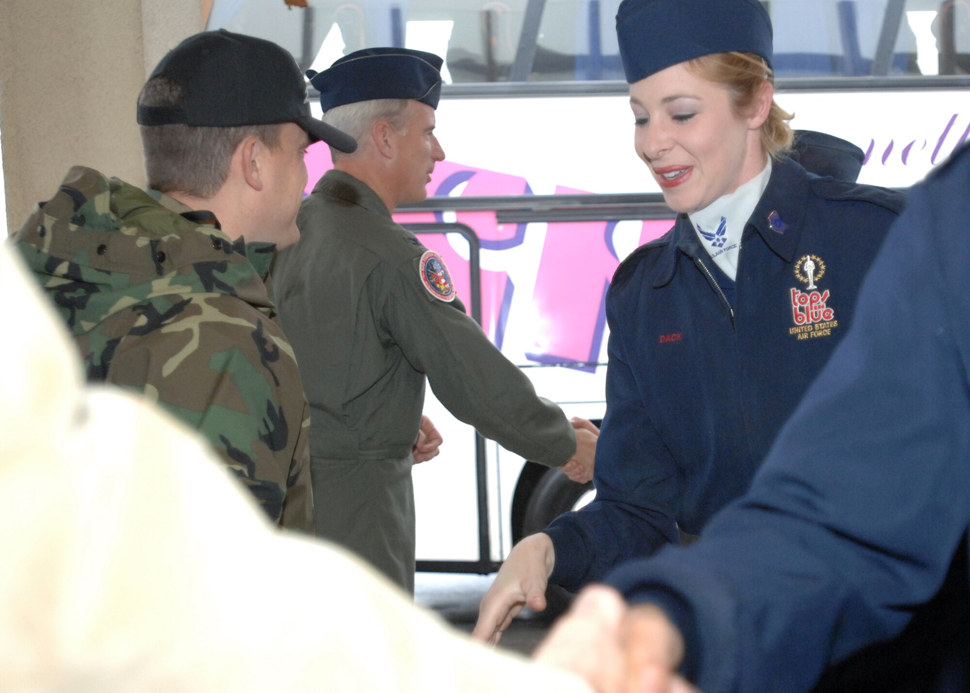 SPANGDAHLEM AIR BASE, Germany – Tech. Sgt. Jennifer Dack, from the Air Force performance group Tops In Blue, is greeted by  Col. Thomas Feldhausen, 52nd Fighter Wing vice commander, and Maj. Michael Wyatt, 52nd Services Squadron commander, at the Brick House Oct. 29. (U.S. Air Force photo/Airman 1st Class Jenifer Calhoun)