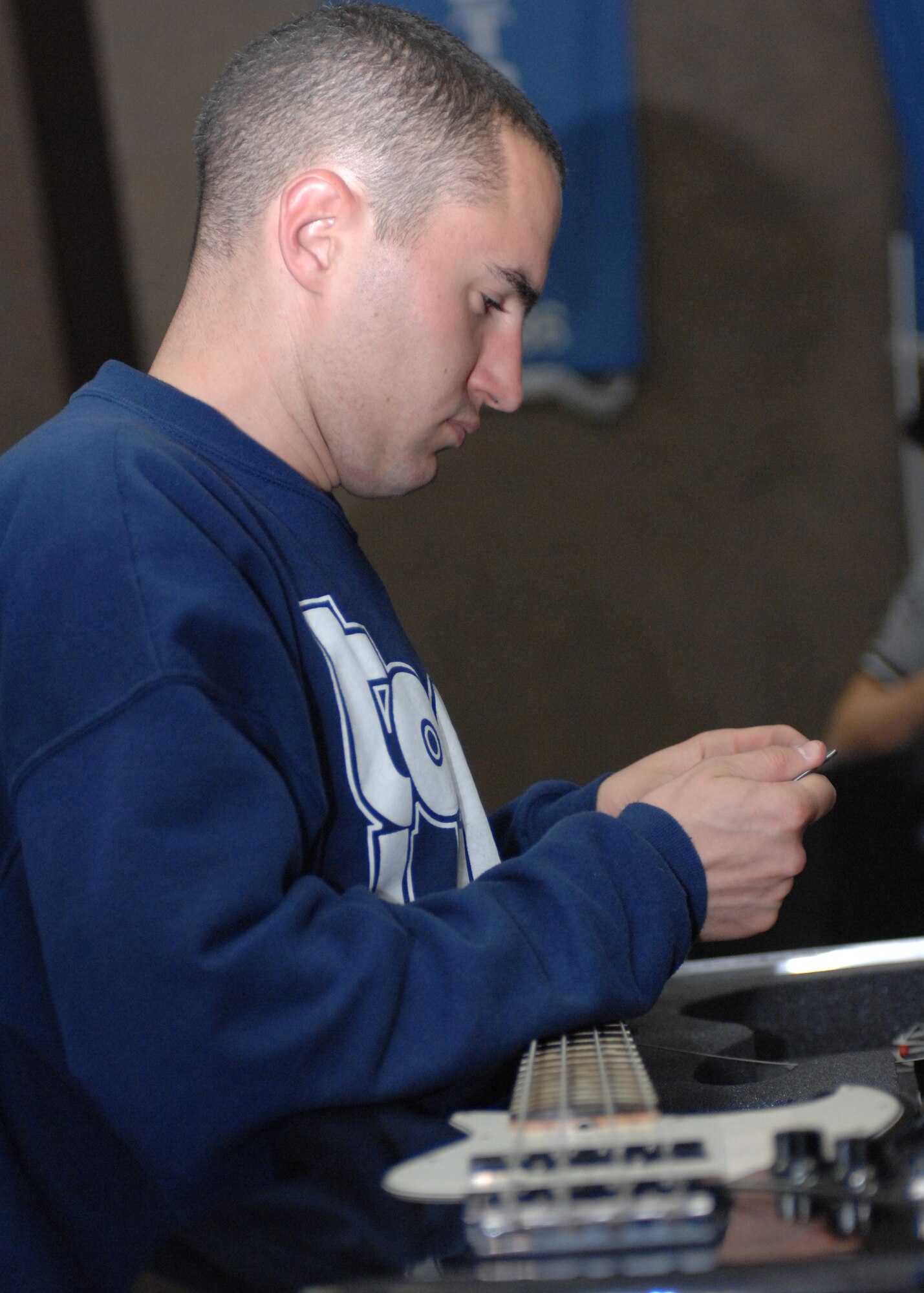 SPANGDAHLEM AIR BASE, Germany -- Staff Sgt. Mark Schmidt, from the Air Force performance group Tops In Blue, restrings his bass guitar at Skelton Memorial Fitness Center to prepare for the Tops In Blue performance here Oct. 30. (U.S. Air Force photo/Airman 1st Class Jenifer Calhoun)