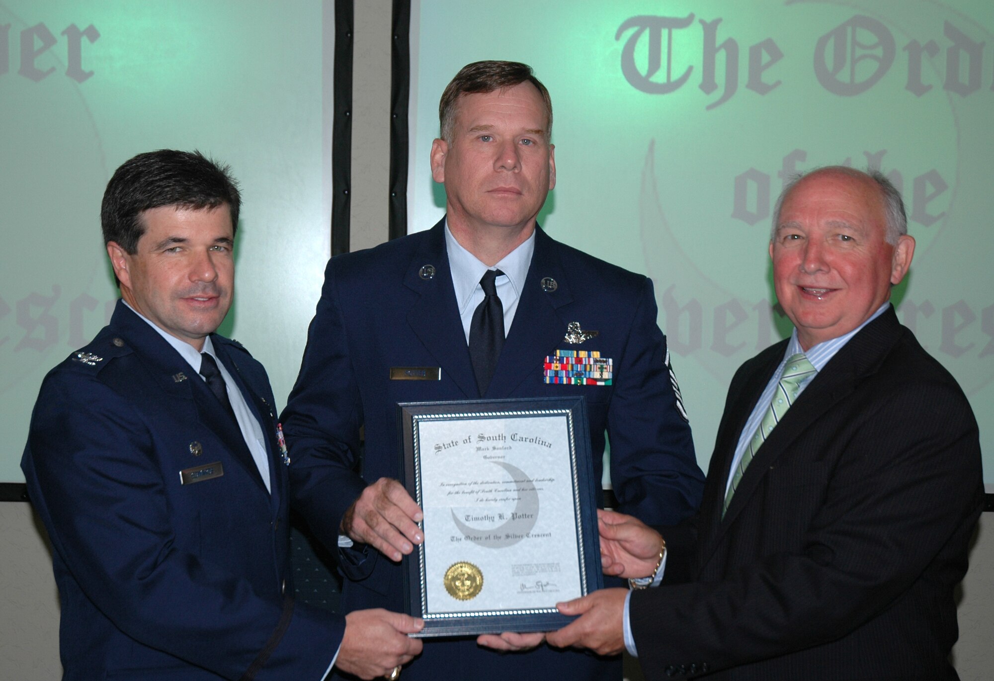 Master Sgt. Tim Potter (center) is presented with the Order of the Silver Crescent, South Carolina's highest honor for volunteer and community service, by S.C. Sen. Paul Campbell and Col. Bill Edwards (left), 300 AS commander.  (Photo by Maj. Bill Walsh, USAFR)