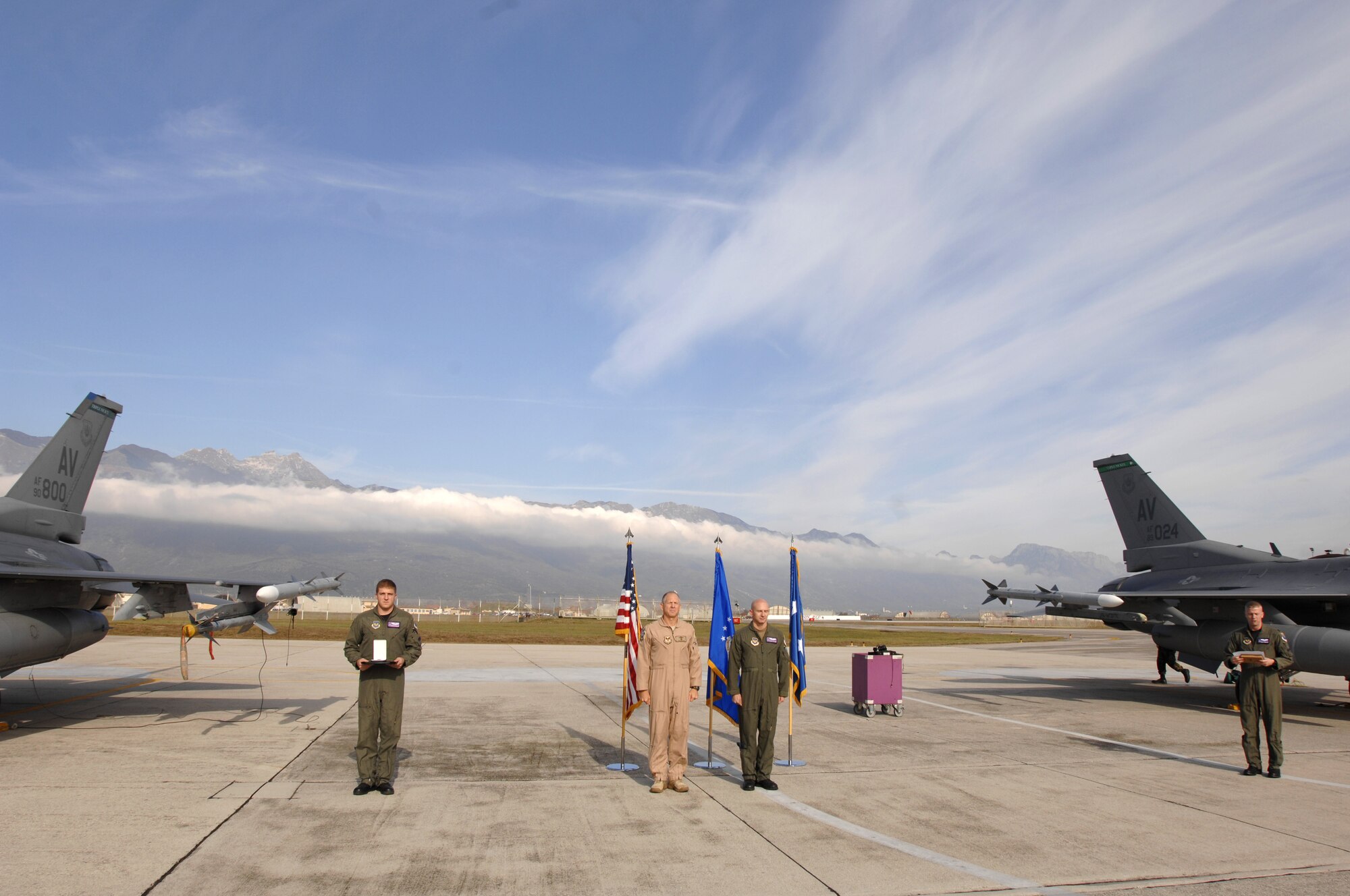AVIANO AIR BASE, Italy--Capt. George Collings and his father and fellow F-16 pilot Major Gen. Michael Collings, the Senior U.S. Defense Representative to Egypt, stand at attention during a Distinguished Flying Cross ceremony on the flightline Oct. 29.  General Collings flew into Aviano Air Base to present Capt. Collings with the medal for distinguishing himself by extraordinary achievement while participating in aerial flight as an F-16CG pilot with the 510th Expeditionary Fighter Squadron based out of Balad Air Base, Iraq. (U.S. Air Force photo/Senior Airman Patrick Dixon) 