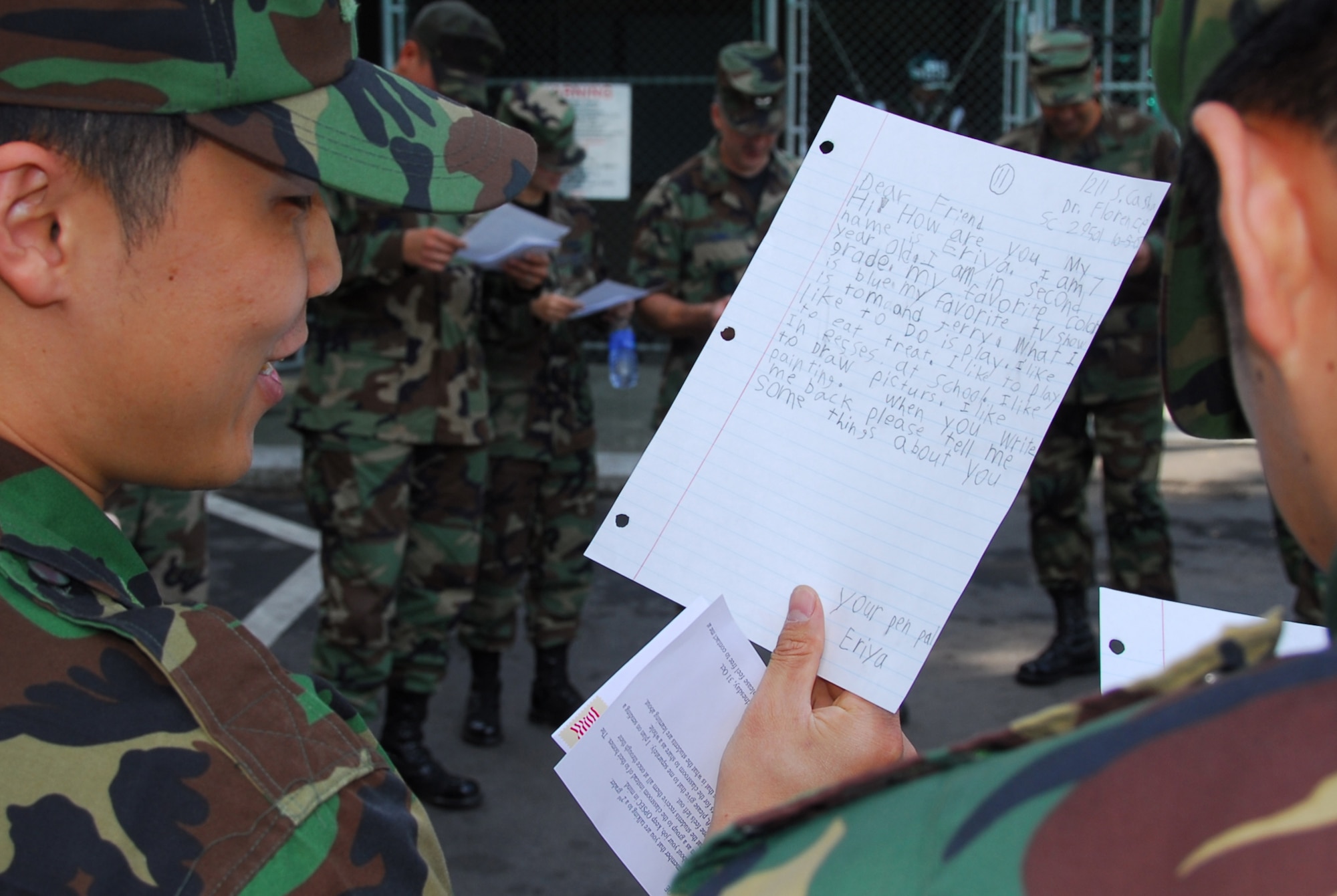 OSAN AIR BASE, Republic of Korea --  Airmen with the Republic of Korea Air Force read a letter from a 2nd grade students at Delmae Heights Elementary School on Oct. 26. Tech. Sgt. C.J. Baker, 607th Air Intelligence Squadron, and Veronica Flowers, a teacher at Delmae Heights in Florence, S.C., started a program in which Osan Airmen will be pen pals for one year with her 20 students. (U.S. Air Force photo by Staff Sgt. Ronnie Hill)