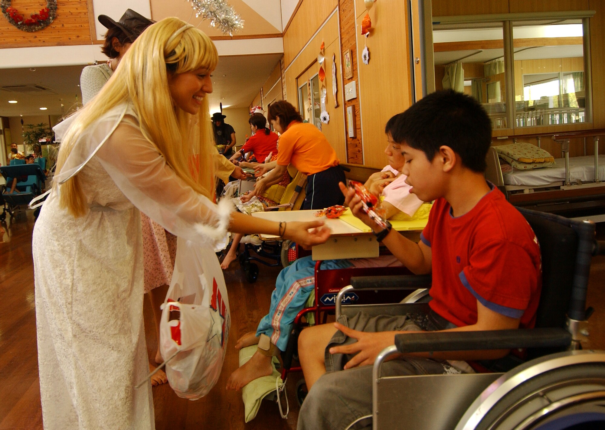 Staff Sgt. Julie Anzo, 17th Special Operations Squadron, passes out candy to the physically disabled children from the Okinawa Children Development Center in Okinawa, Japan, Oct. 27, 2007.