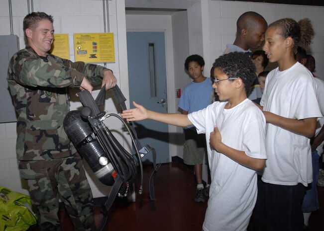 Airman 1st Class Kason Fitzpatrick, 437th Civil Engineer Squadron firefighter, helps Robert Mims, part of a group from Winwood Farm, put on a self-contained breathing apparatus during the CFC Shadow Program tour Oct. 26. (U.S. Air Force photo/Airman 1st Class Cynthia Spalding)