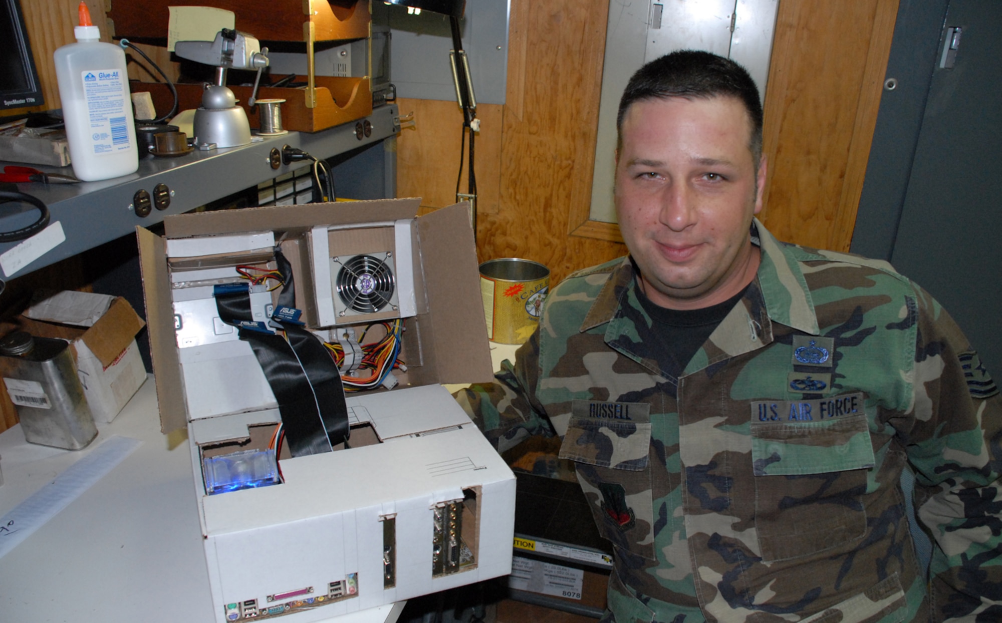 SOTO CANO AIR BASE, Honduras -- Tech. Sgt. Robert Russell, Armed Forces Network Honduras chief engineer, shows off his "Frankenstein computer" he built from spare parts and a shipping box. The computer took about two weeks to build, since he had to wait on the glue to dry and cure after each computer component was added.  (U.S. Air Force photo/Tech. Sgt. Sonny Cohrs)