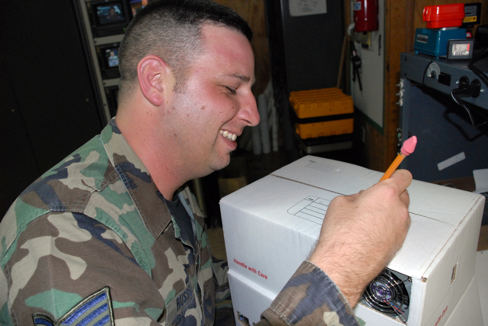 SOTO CANO AIR BASE, Honduras -- Tech. Sgt. Robert Russell, Armed Forces Network Honduras chief engineer, addresses his "shipping box" computer he built from spare parts to his wife.  The computer took about two weeks to build, since he had to wait on the glue to dry and cure after each computer component was added.  (U.S. Air Force photo/Tech. Sgt. Sonny Cohrs)