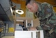 SOTO CANO AIR BASE, Honduras -- Tech. Sgt. Robert Russell, Armed Forces Network Honduras chief engineer, makes an adjustment to his "Frankenstein computer" he built from spare parts and a shipping box. The computer took about two weeks to build, since he had to wait on the glue to dry and cure after each computer component was added.  (U.S. Air Force photo/Tech. Sgt. Sonny Cohrs)