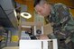 SOTO CANO AIR BASE, Honduras -- Tech. Sgt. Robert Russell, Armed Forces Network Honduras chief engineer, makes an adjustment to his "Frankenstein computer" he built from spare parts and a shipping box. The computer took about two weeks to build, since he had to wait on the glue to dry and cure after each computer component was added.  (U.S. Air Force photo/Tech. Sgt. Sonny Cohrs)