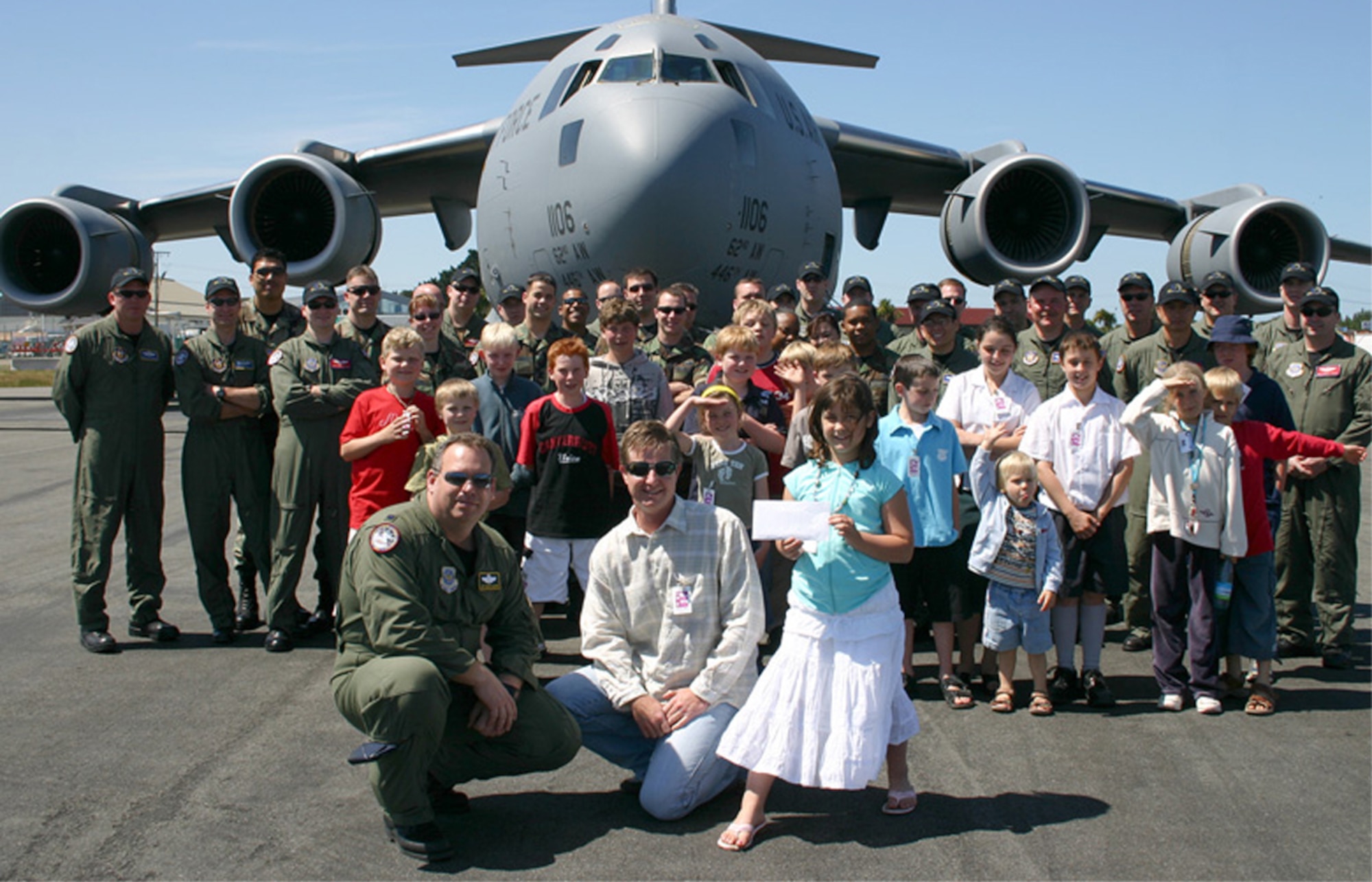 Reserve and active-duty Airmen from the 446th and 62nd Airlift Wings taking part in Operation Deep Freeze present a check to the "Cookie Munchers" organization. Each year the Airmen from McChord Air Force Base, Wash., contribute to a different organization located in their Operation Deep Freeze staging area, Christchurch, New Zealand.  (U.S. Air Force photo)