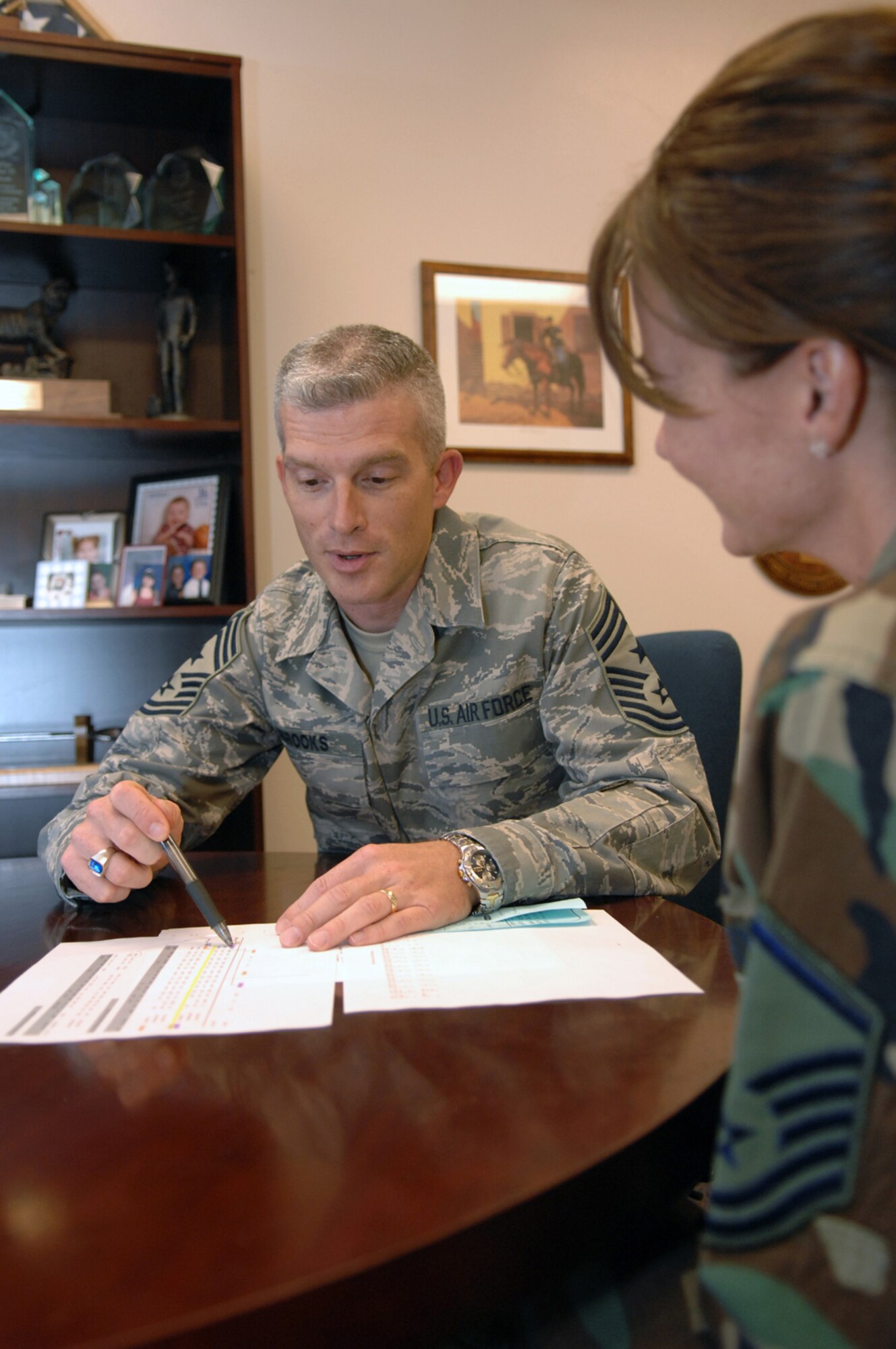 The new 99th Air Base Wing Command Chief Master Sgt., Rob Brooks, reviews daily taskings with his executive assistant, Master Sgt. Kristin Daugherty. (U.S. Air Force photo by Senior Airman Larry E. Reid Jr.)
