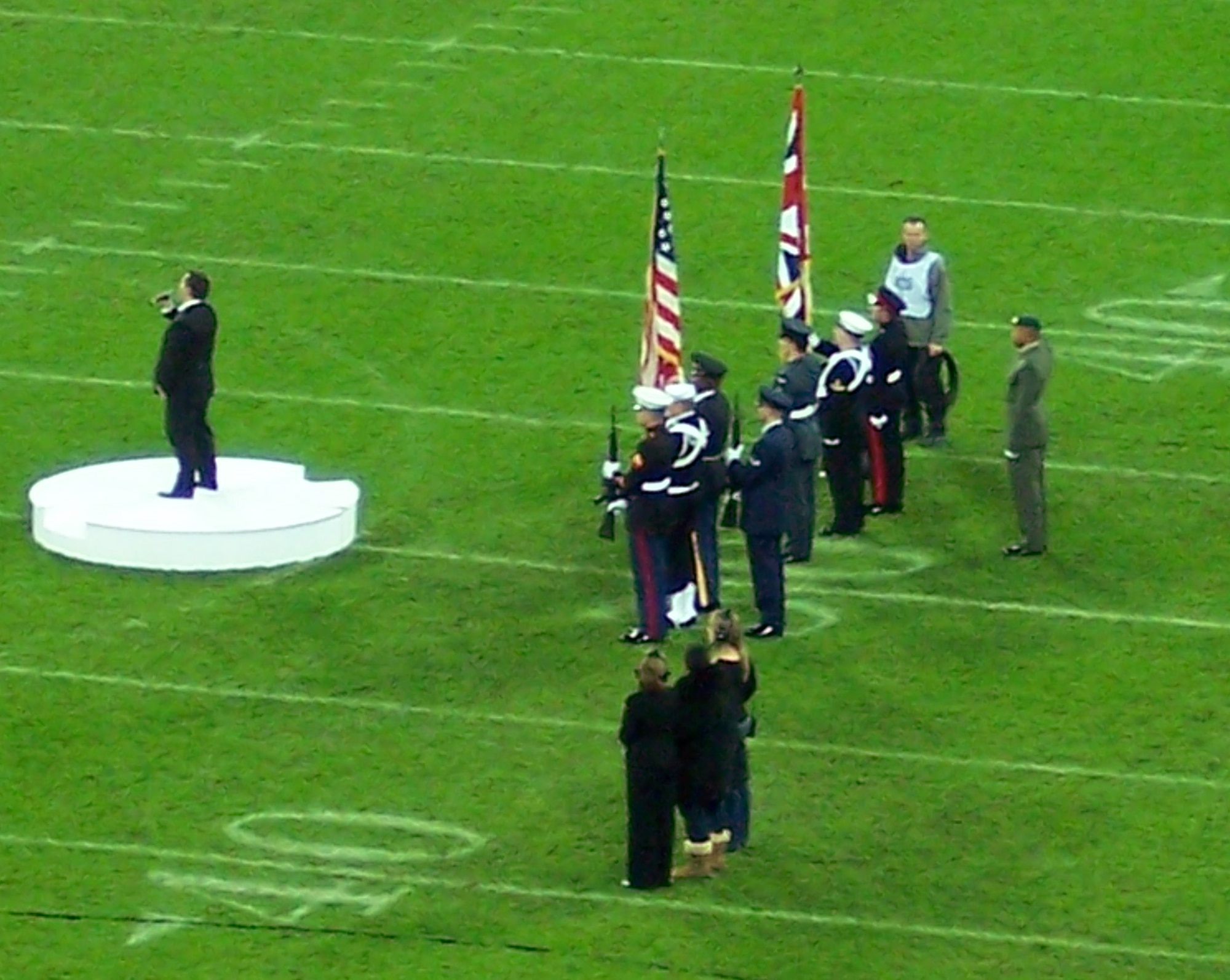 US & UK color guards stand at attention as "God Save The Queen" is sung by Mr. Paul Potts, winner of a recent British talent show, at the opening ceremonies of the September 28th National Football League first ever regular season game to be played in London, England.  The "Star Spangled Banner" was sung prior to the UK national anthem at the NY Giants vs. Miami Dolphins game. The US Color guard was from the U.S. European Command Joint Analysis Center at Royal Air Force Molesworth, England.  The UK Joint Services Colour Guard included members from the British Army, Royal Navy, Royal Marines and Royal Air Force.  (Photo Courtesy of Russell Lucier)