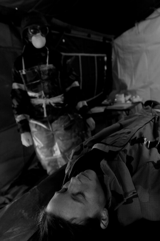 LANGLEY AIR FORCE BASE, Va. -- Airman Jeremy Bass, a mortuary technician for the 1st Services Squadron, simulates processing the remains of Staff Sgt. Laura Fournier also a mortuary technician with the 1st SVS who is simulating a casualty during the Phase II exercise Oct. 30.  The Phase II exercise trains Airmen to deal with various war time contingencies in a simulated environment.(U.S. Air Force photo/Senior Airman Christopher L. Ingersoll)