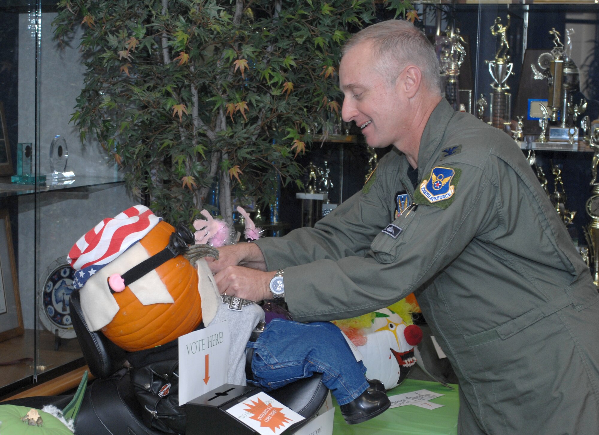 WHITEMAN AIR FORCE BASE, Mo. --  Col. Garrett Harencak, 509th Bomb Wing commander, pins his choice at the 509th Medical Group's first-ever pumpkin contest award ceremony Oct. 31. The contest began Oct. 24 with various units throughout the group submitting their pumpkins up for display and voting. (U.S. Air Force photo/Tech. Sgt. Samuel A. Park)