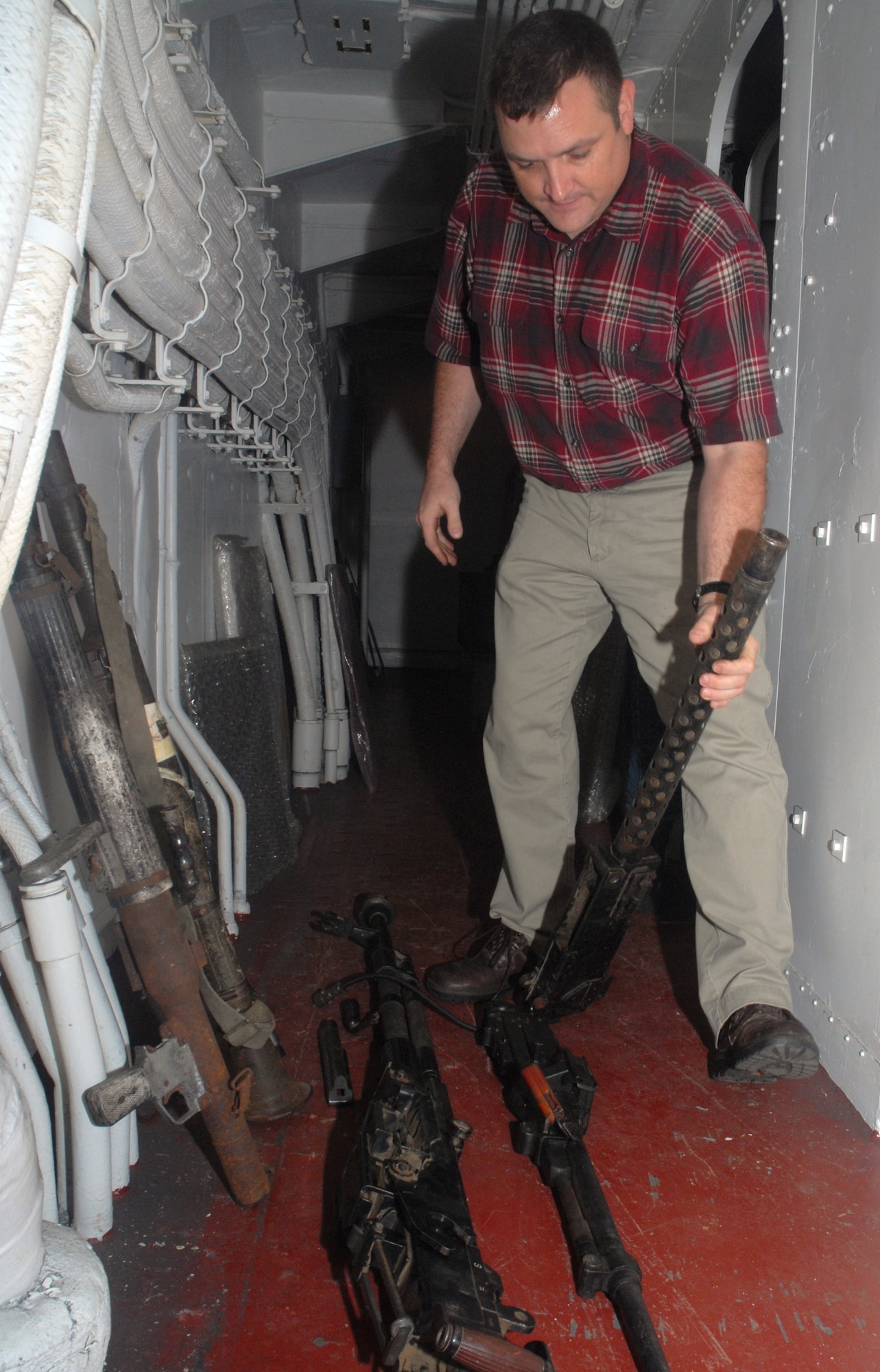 Steven Gottula, 437 CES Readiness and Emergency Management Flight, Charleston AFB Guardian Program manager, positions the weapons to be placed in the armory safe on the USS Yorktown.  The weapons will stay there until they start the restoration process. (U.S. Air Force photo/Staff Sgt. Jennifer Arredondo)