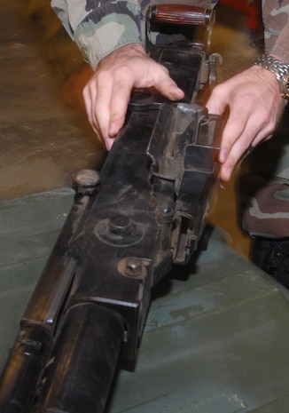 Sergeant Marino inspects the chamber area of the SG-43 machine gun before being transported to the Patriots Point and Naval Museum Oct. 19. (U.S. Air Force photo/Staff Sgt. Jennifer Arredondo)