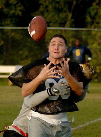 Anthony Dyer, 437th Civil Engineer Squadron, tries to catch a ball but is fouled by an opposing member from the Navy team during a flag football game Tuesday night on base.  (U.S. Air Force photo/Airman 1st Class Nicholas Pilch)