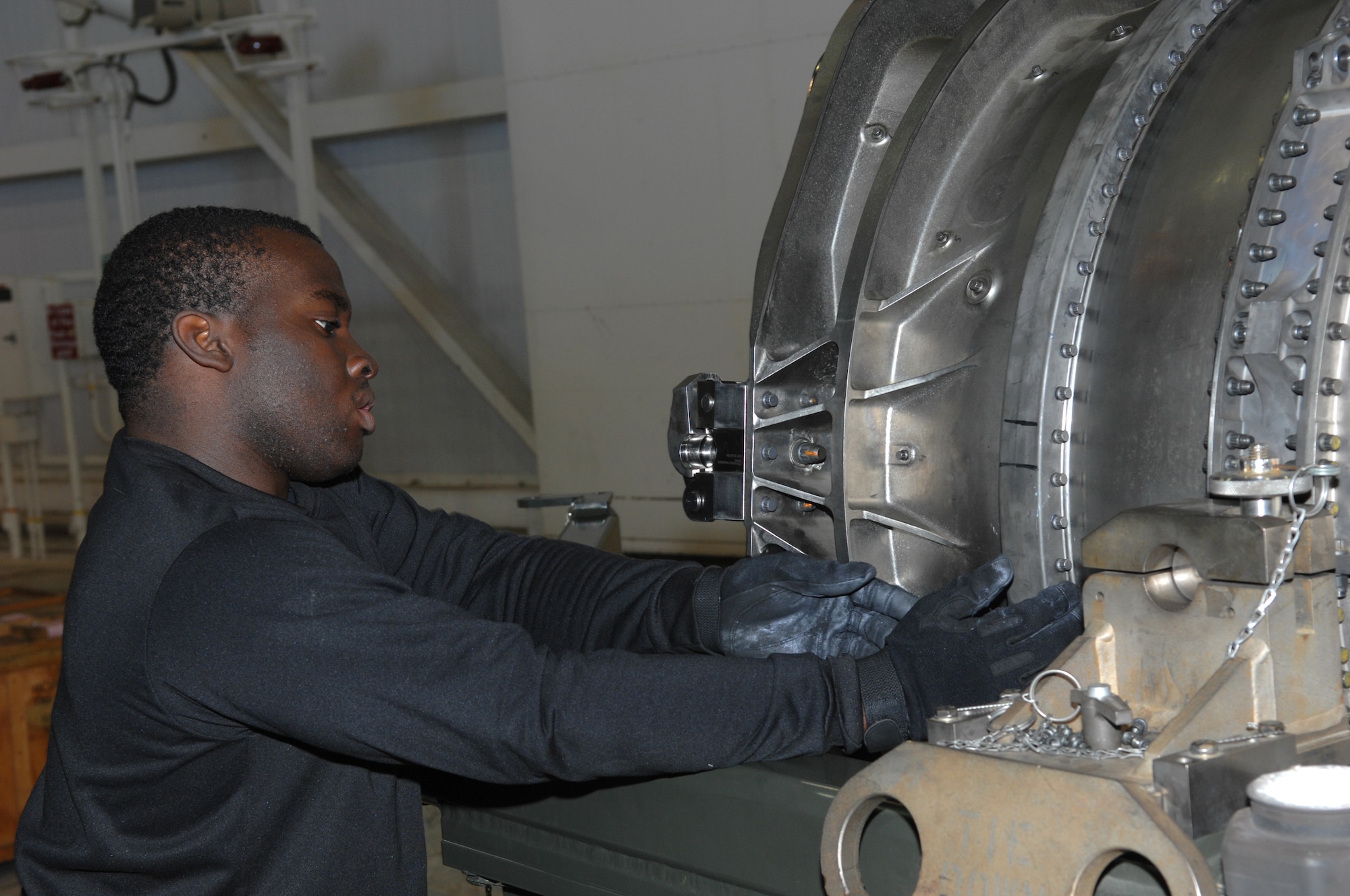 WHITEMAN AIR FORCE BASE, Mo. -- Airman Eric Prince, 509th Aircraft Maintenance Squadron, works to connect the forward tell pipe to the GE-F118 engine in preparation for installation Oct. 24. (U.S. Air Force photo/Airman 1st Class Stephen Linch)