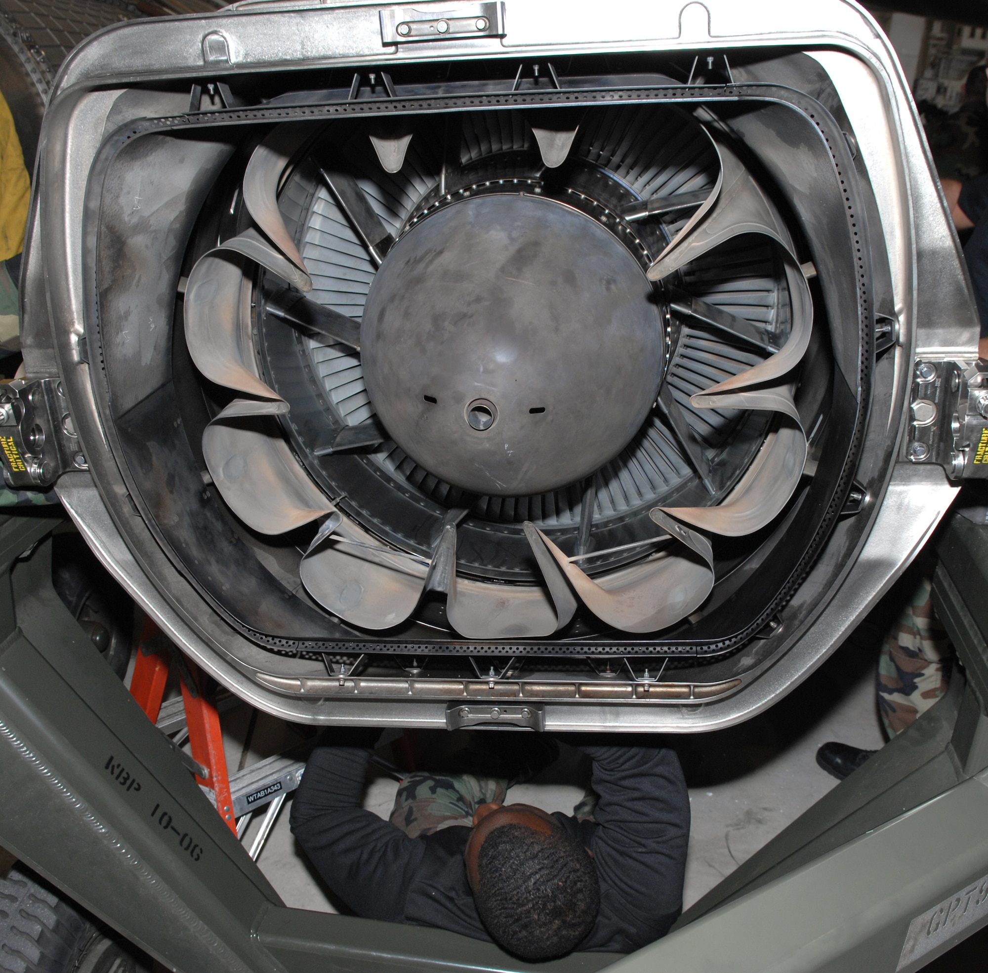 WHITEMAN AIR FORCE BASE, Mo. -- Airman Eric Prince, 509th Aircraft Maintenance Squadron, works from the bottom of the engine to connect the forward tell pipe to the GE-F118 engine in preparation for installation Oct. 24. (U.S. Air Force photo/Airman 1st Class Stephen Linch)