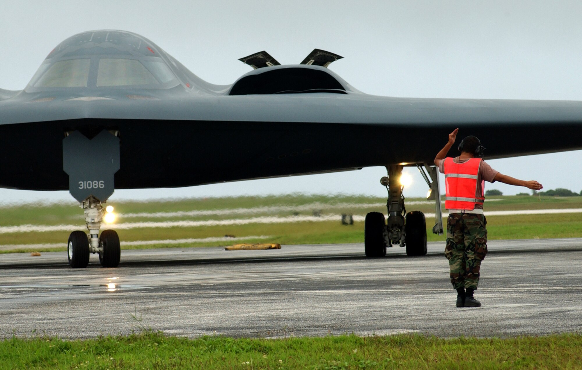 A lone crew chief launches a B-2 Spirit stealth bomber for a training combat sortie Oct. 24 on the Pohakuloa Training Area, Hawaii. They practiced combat operations while working with joint terminal attack controllers on the ground that were calling in coordinates. (Air Force photo/Senior Airman Brian Kimball)