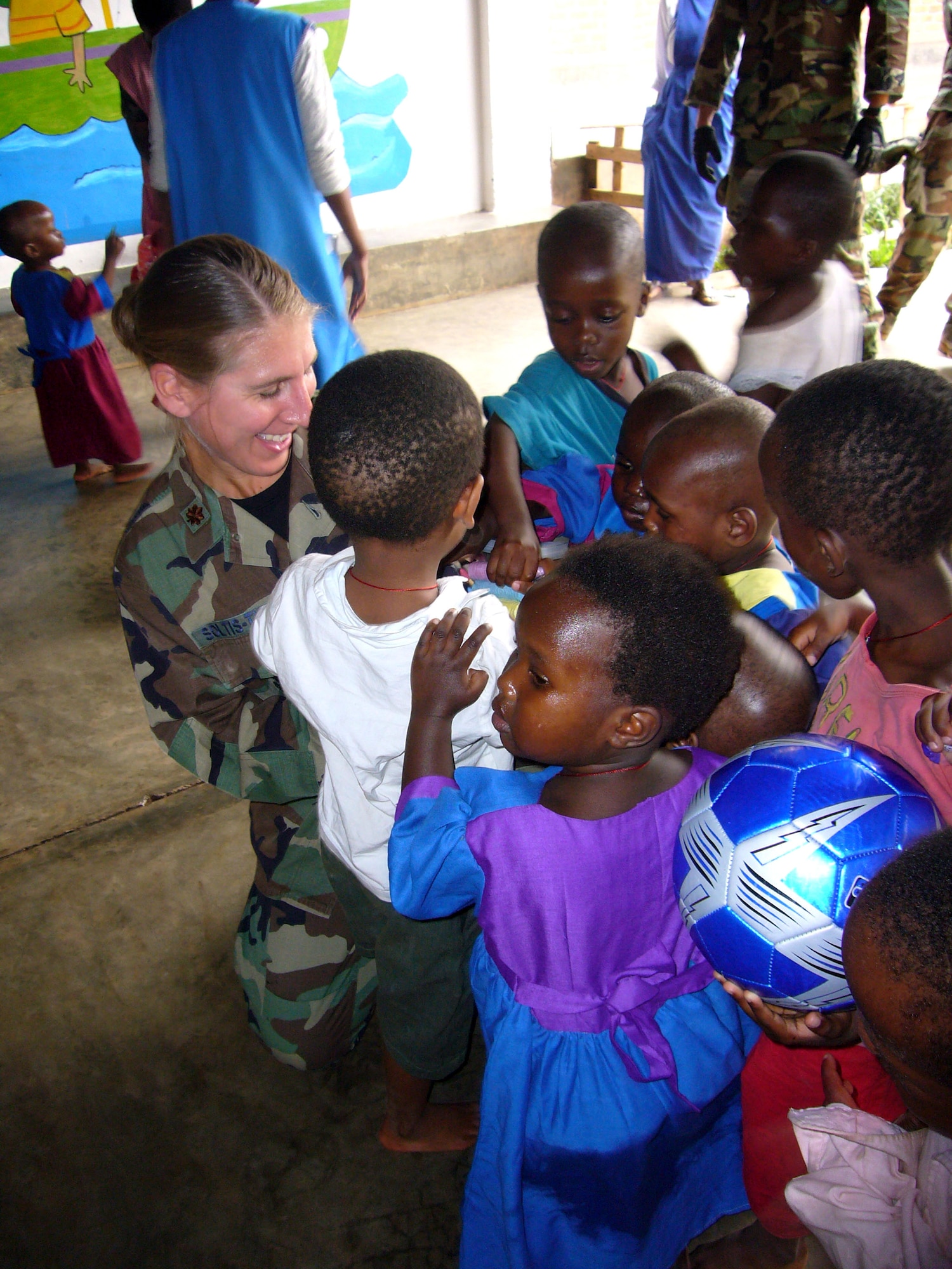 Maj. (Dr.) Kristen Soltis-Tyler, 786th Air Expeditionary Squadron flight surgeon, hands out candy to children at an orphanage in Kigali, Rwanda, Oct. 27. Major Soltis-Tyler was part of a group of Airmen who visited the orphanage to donate coloring books, soccer balls and shoes to the children. The Airmen are in Kigali to provide airlift support to the Rwanda Defense Force. (U.S. Air Force photo/Capt. Erin Dorrance)