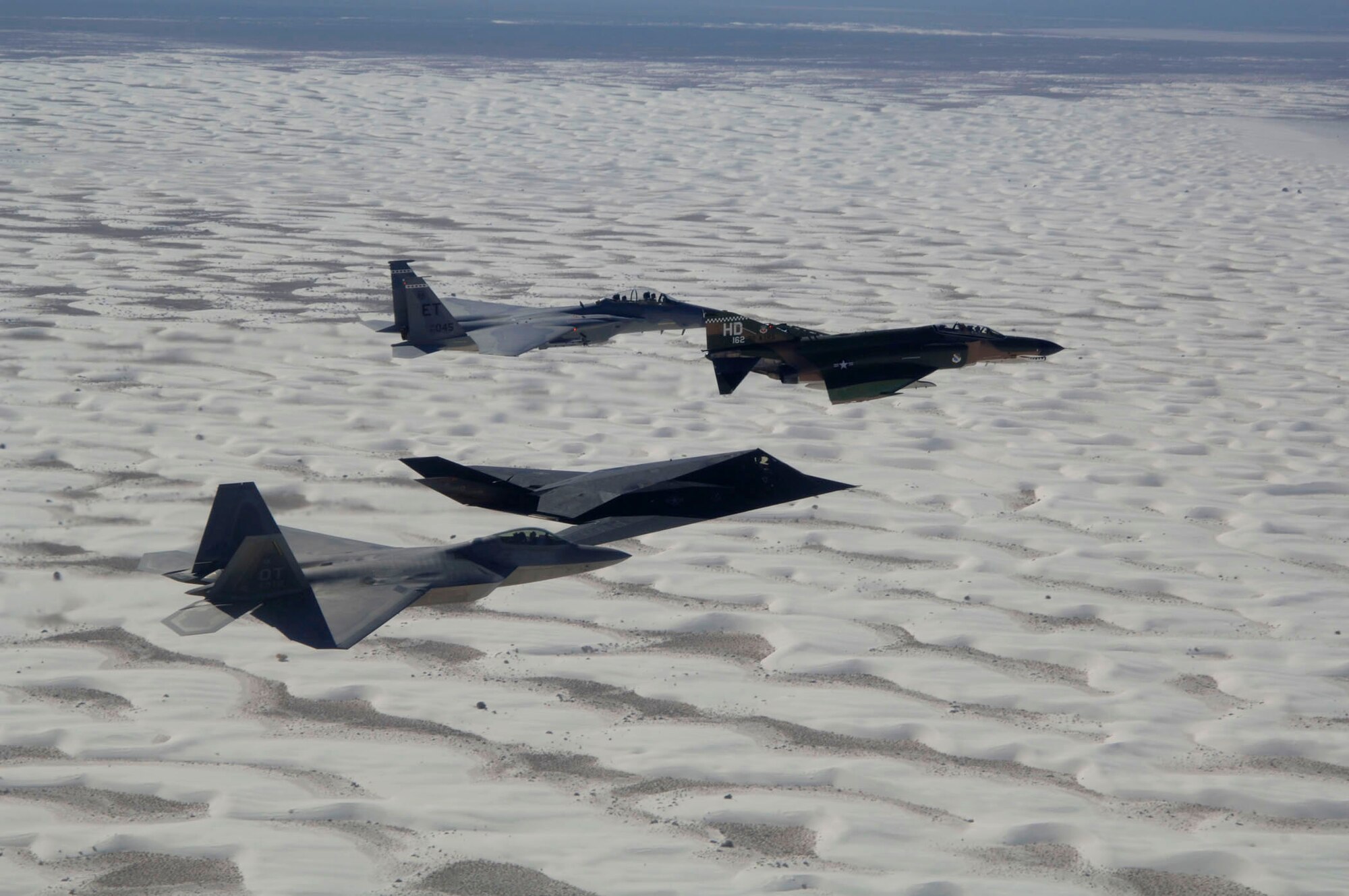 An F-22 Raptor, an F-117 Nighthawk, an F-4 Phantom and an F-15 Eagle fly above the clouds over Holloman Air Force Base, N.M. Oct. 27 during the Holloman Air and Space Expo.  The expo showcased Air Force capabilities and the 49th Fighter Wing. (U.S. Air Force photo/Senior Airman Russell Scalf)