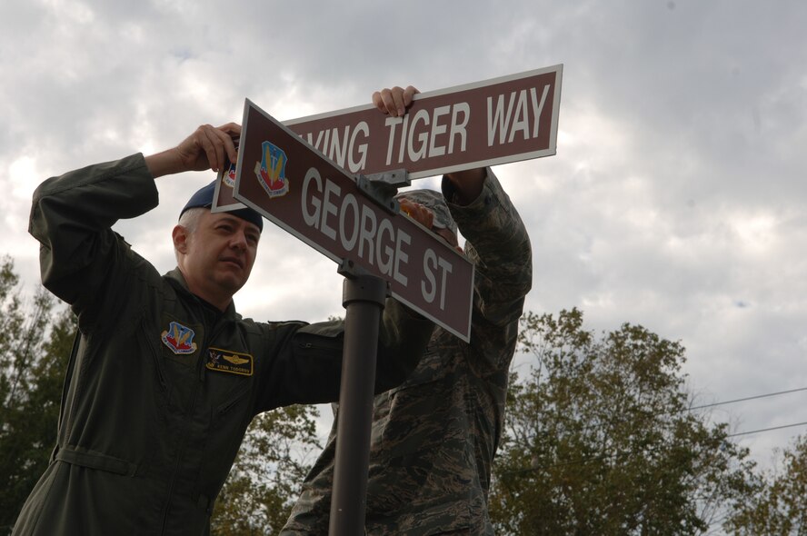 MOODY AIR FORCE BASE, Ga. -- Col. Kenneth Todorov, 23rd Wing commander, secures the new Flying Tiger Way road sign at the intersection of the newly renamed street and George Street as Staff Sgt. Butch Stewart, 23rd Civil Engineer Squadron, assists Oct. 31.  Base leadership decided to rename the street to honor the Flying Tiger heritage the base maintains.  The address for the 23rd Wing headquarters is now  23 Flying Tiger Way.  (U.S. Air Force photo by Senior Airman Schelli Jones)
