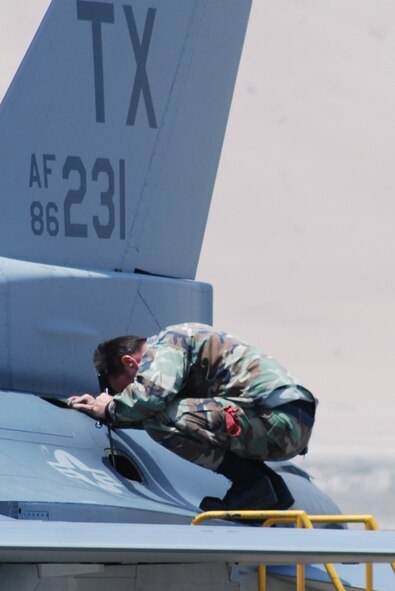Tech. Sgt. John Hutchinson, F-16 crew chief, inspects the clamps on pneumatic lines.  (U.S. Air Force Photo/Laura Dermarderosian-Smith)
