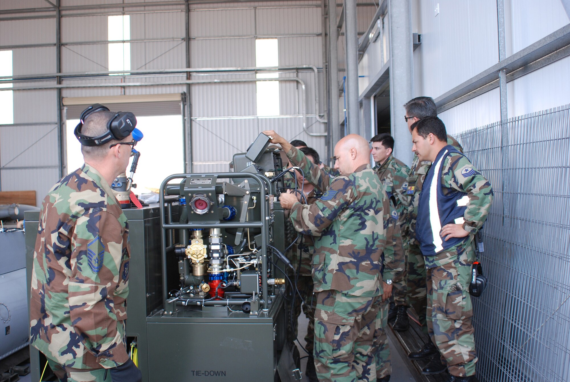 Tech. Sgts. Steven Van Kleeck, left, and Randy Loyer, center, are conducting training on a universal external tank certifier. (U.S. Air Force Photo/Laura Dermarderosian-Smith)