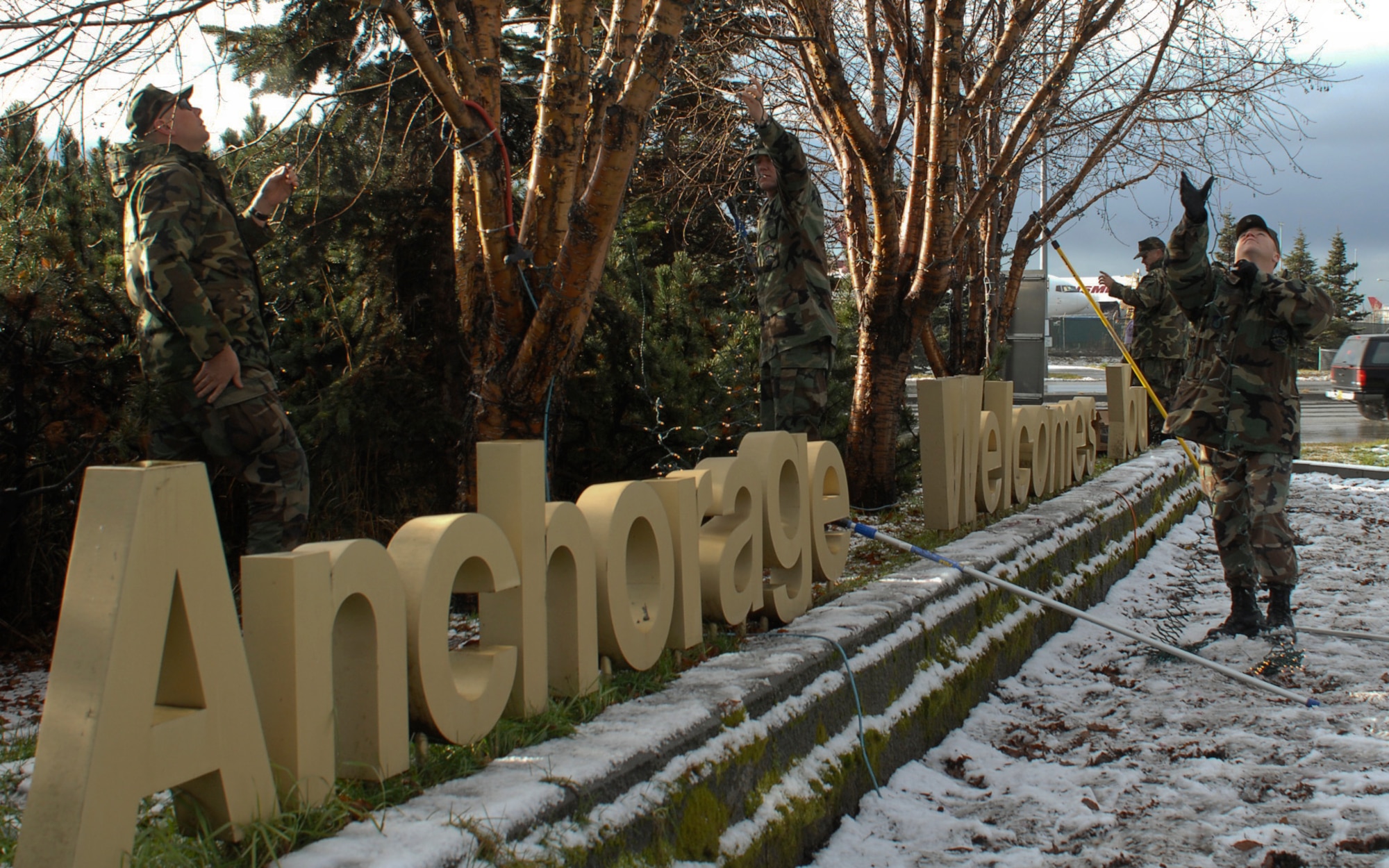 Airmen of the 3rd Civil Engineer Squadron string lights around the “Anchorage Welcomes You” sign near the Ted Stevens International Airport. (Photo by Airman 1st Class Tinese Treadwell)