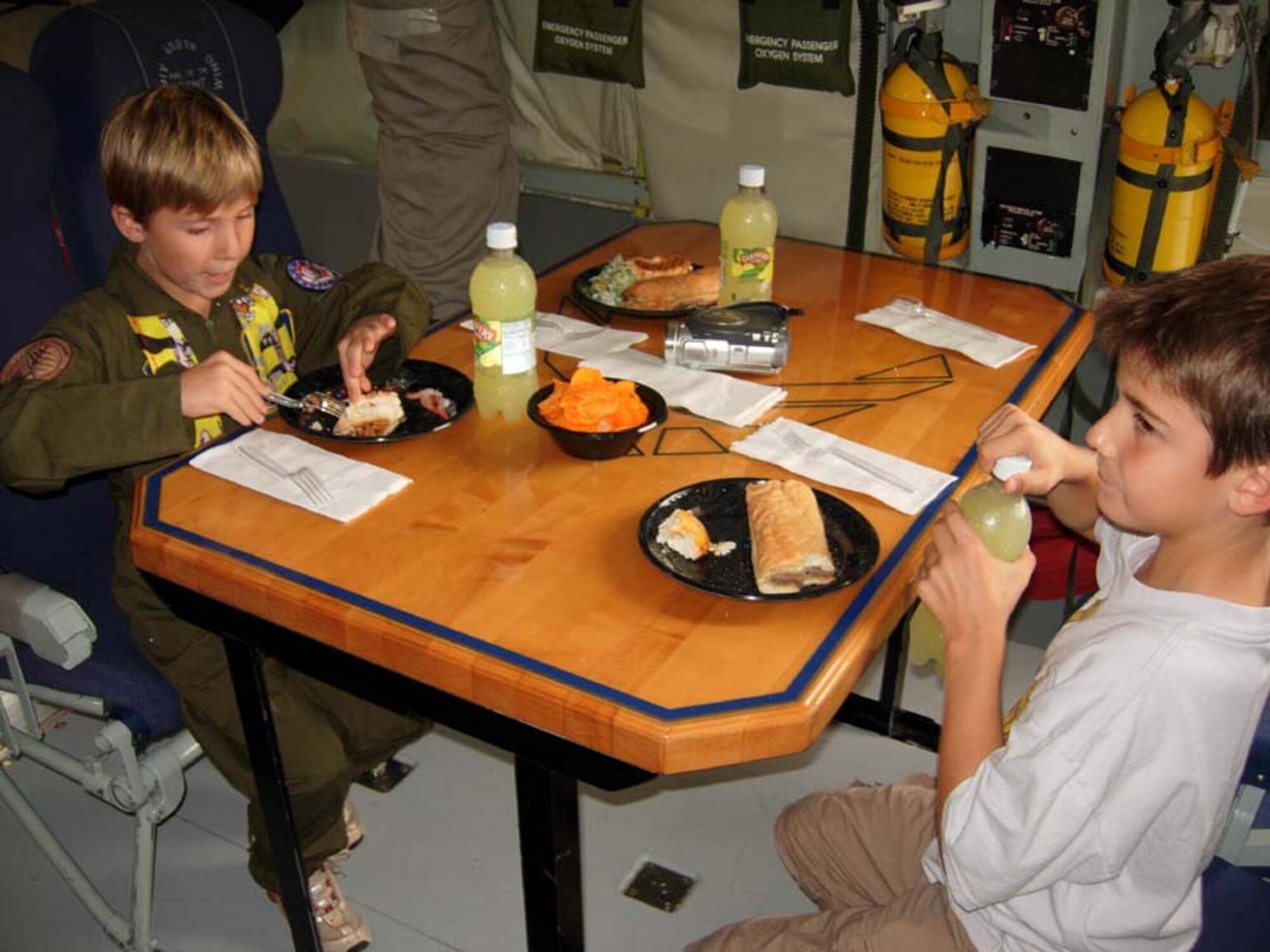 ANDREWS AIR FORCE BASE, Md. -- Griffin Bathras, 7, and his brother Camden, 9, munch on cheese steak sandwiches and shrimp cocktail as part of the D.C. Air National Guard and 459th Air Refueling Wing joint venture "Pilot for a Day" here Oct. 4. The outreach program offers aircraft and squadron tours, lunch and full accommodations for children with serious or chronic conditions. The child also receives a personal pilot flight suit as he or she takes the pilot's oath. (U.S. Air Force photo/Staff Sgt. Amaani Lyle)