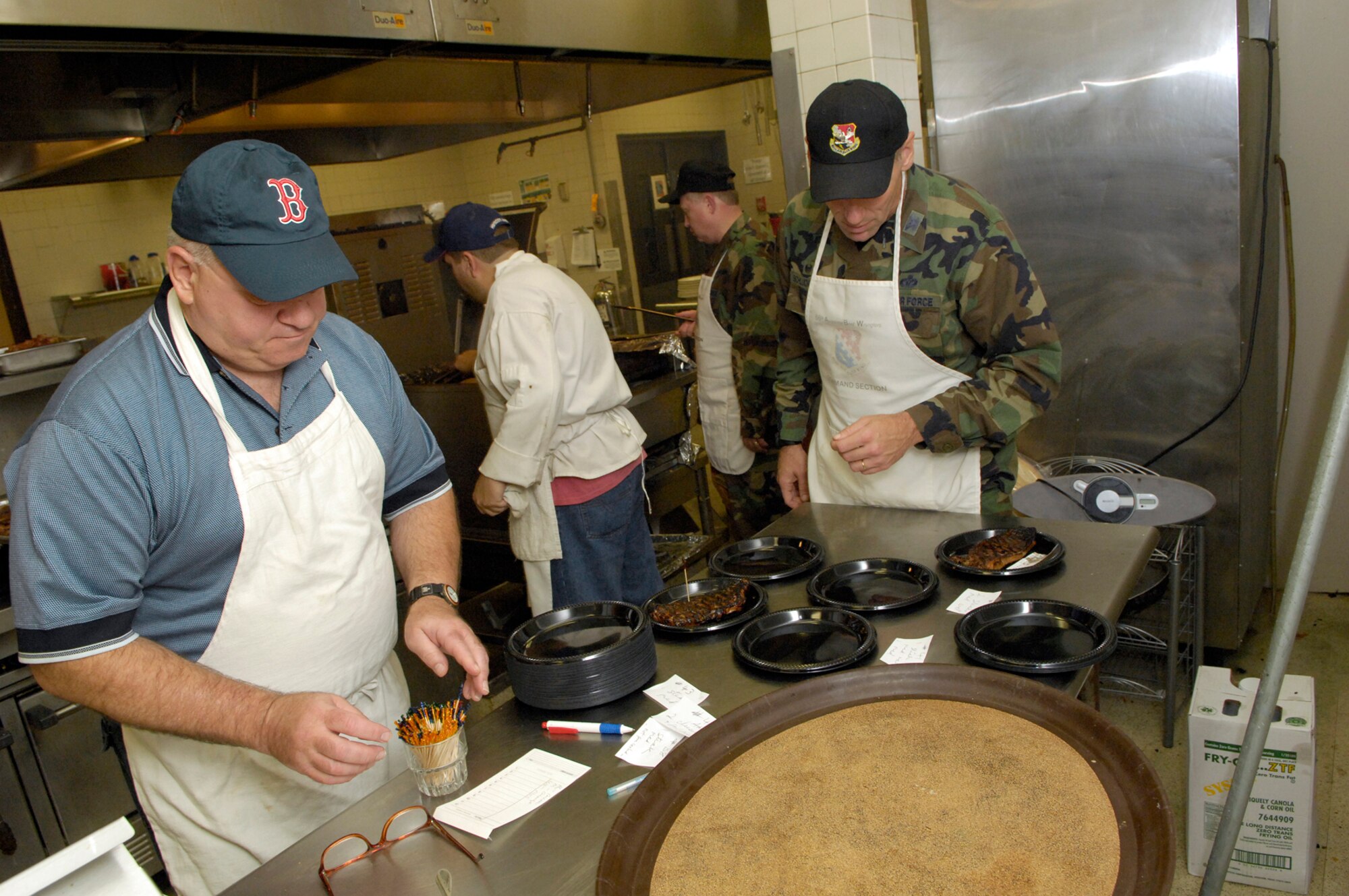 HANSCOM AFB, Mass. -- Col. Nick Zallas (far left), Individual Mobilization Augmentee to the 66th Air Base Wing commander, and Col. Tom Schluckebier (far right), 66th ABW commander, review orders for steaks during Steak Night held Oct. 30 at the Minuteman Club. All proceeds from the event were donated to this years Combined Federal Campaign. The Hanscom community has raised $181,387.58 so far, reaching 82 percent of its monetary goal. For more information on CFC, go to http://easternmasscdc.org/index.asp. (U.S. Air Force photo by Mark Wyatt.)

