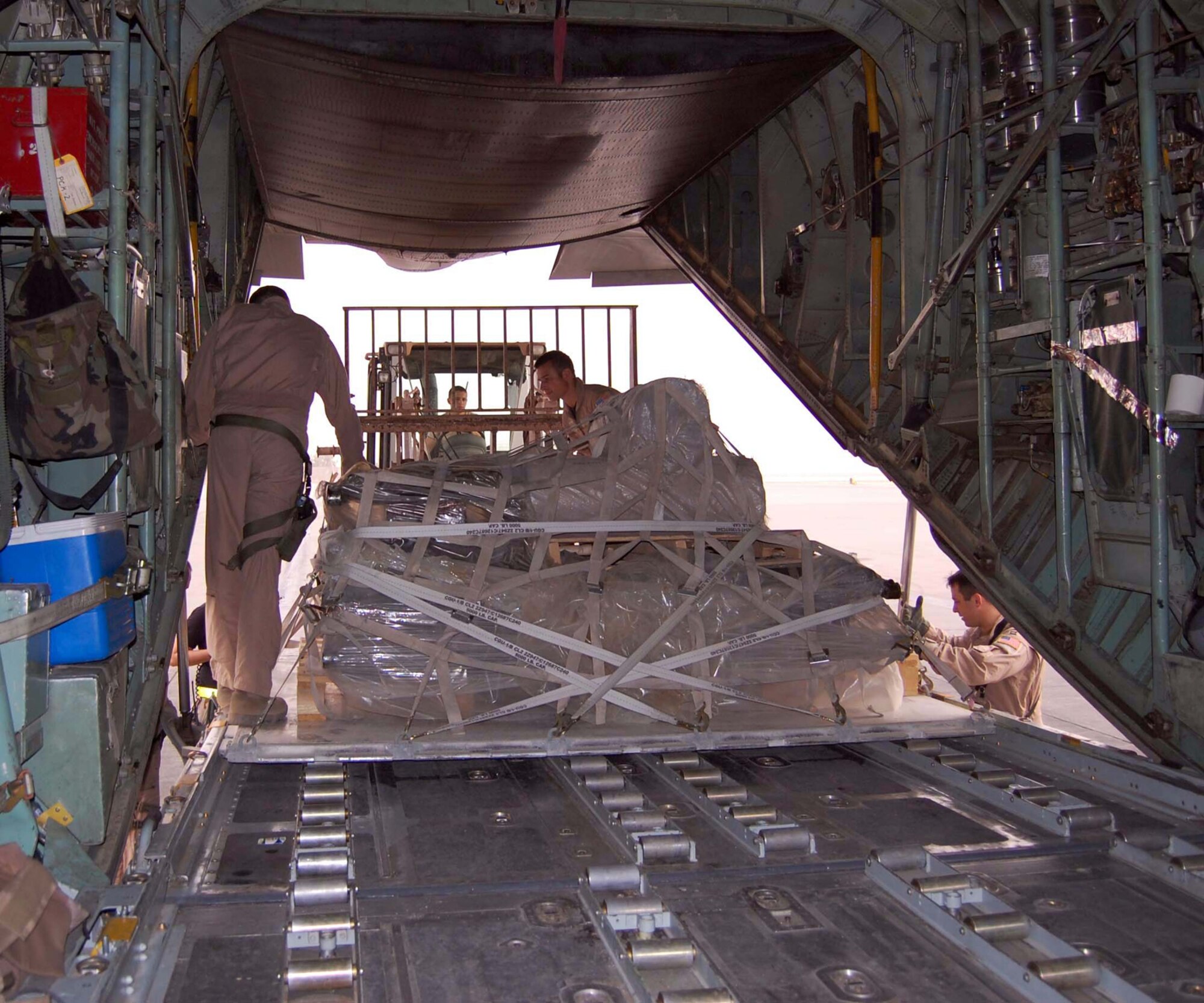 Loadmasters guide a pallet of equipment into the cargo area of a waiting C-130 Hercules at Ramstein Air Base, Germany, Oct. 11. They ensure the load fits properly which is essential for safe transport. (Courtesy photo)