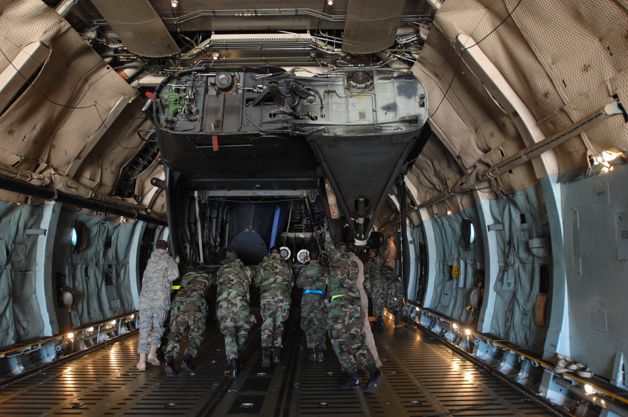 After pulling a 21st Special Operations Squadron MH-53M Pave Low IV helicopter aboard a C-5 Galaxy transport by winch, members of a 352nd Maintenance Squadron load team and the Galaxy crew push the aircraft to its load position, Oct. 5, 2007. Eventually all five Pave Lows assigned to RAF Mildenhall will reside in the 'Boneyard' or the Aerospace Maintenance and Regeneration Group in Tucson, Ariz., due to the aircraft's retirement from the Air Force inventory.  (U.S. Air Force photo by Tech. Sgt. Tracy L. DeMarco)