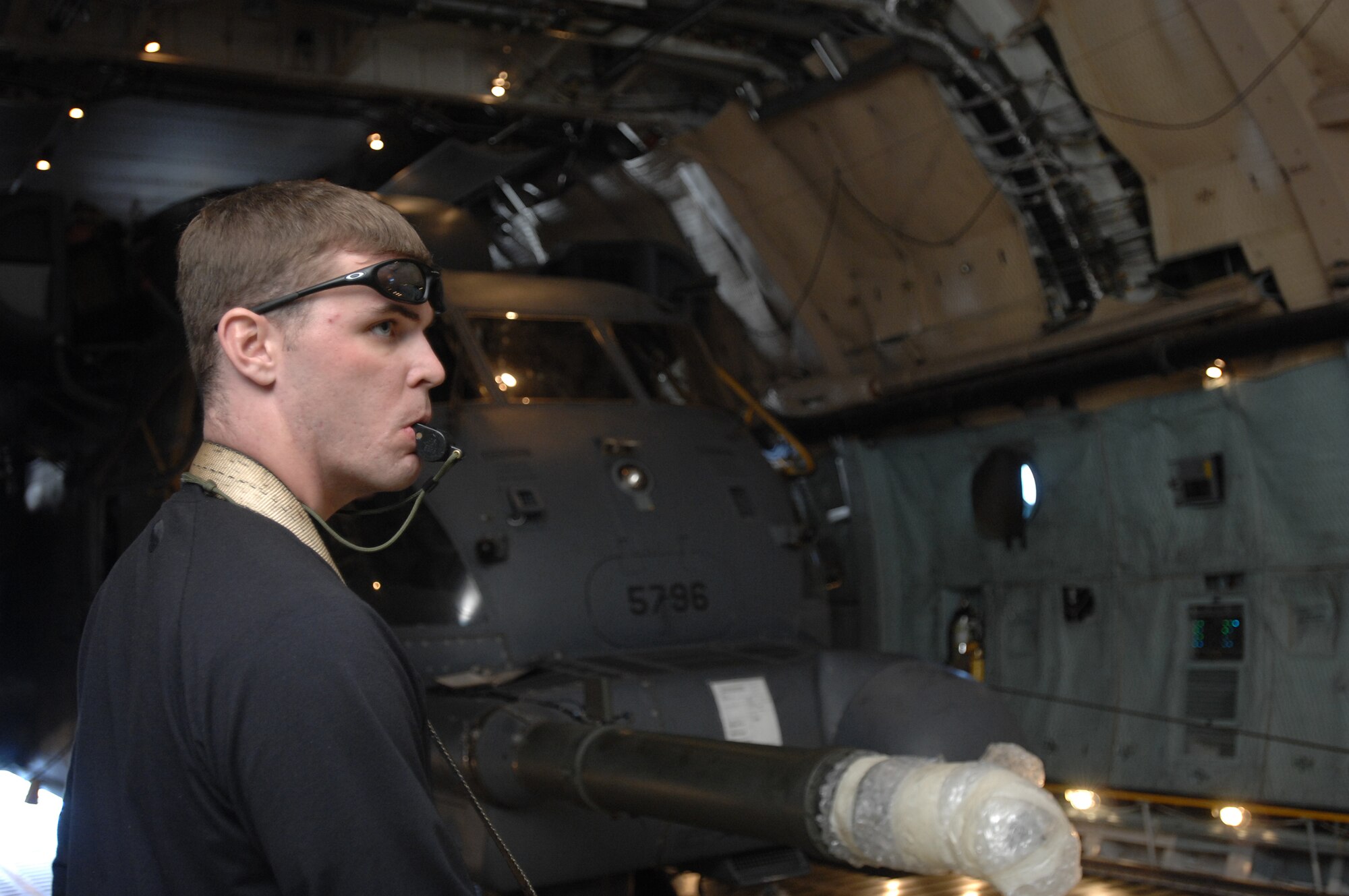 Armed with a whistle, Airman 1st Class William "Wild Bill" Sparks, a member of the 352nd Maintenance Squadron, remains ready to alert the winch operator to stop if he detects or suspects any problems during the load of a 21st Special Operations Squadron MH-53M Pave Low IV helicopter onto a C-5 Galaxy from Travis Air Force Base, Calif., Oct. 5, 2007. The Pave Lows are destined for the Aerospace Maintenance and Regeneration Group in Tucson, Ariz., as a result of being retired to make room for the CV-22 Osprey. (U.S. Air Force photo by Tech. Sgt. Tracy L. DeMarco)
