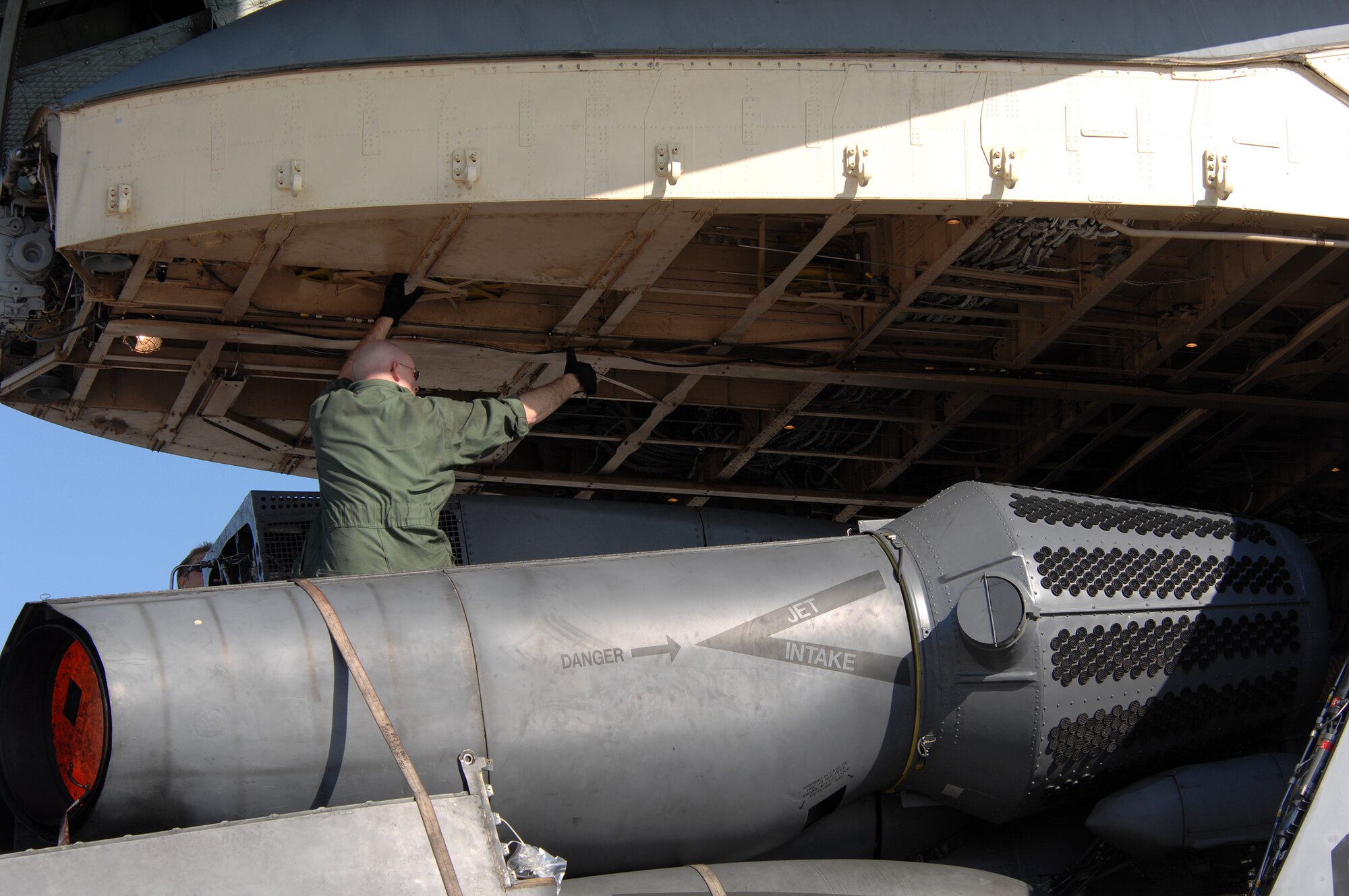 During his first time assisting with a load, Senior Airman Jason Haigt is trusted to ride atop an MH-53M Pave Low IV helicopter while it's loaded on a C-5 Galaxy headed to the 'Boneyard,' Oct. 5, 2007. Due to the aircraft's retirement, the 'Boneyard,' officially known as the Aerospace Maintenance and Regeneration Group in Tucson, Ariz., will eventually store all five Pave Lows assigned to the 21st Special Operations Squadron, RAF Mildenhall. With only inches, and sometimes less than an inch of clearance, all load team members must remain watchful for problems until the Pave Low is parked and secured inside the C-5.
(U.S. Air Force photo by Tech. Sgt. Tracy L. DeMarco)