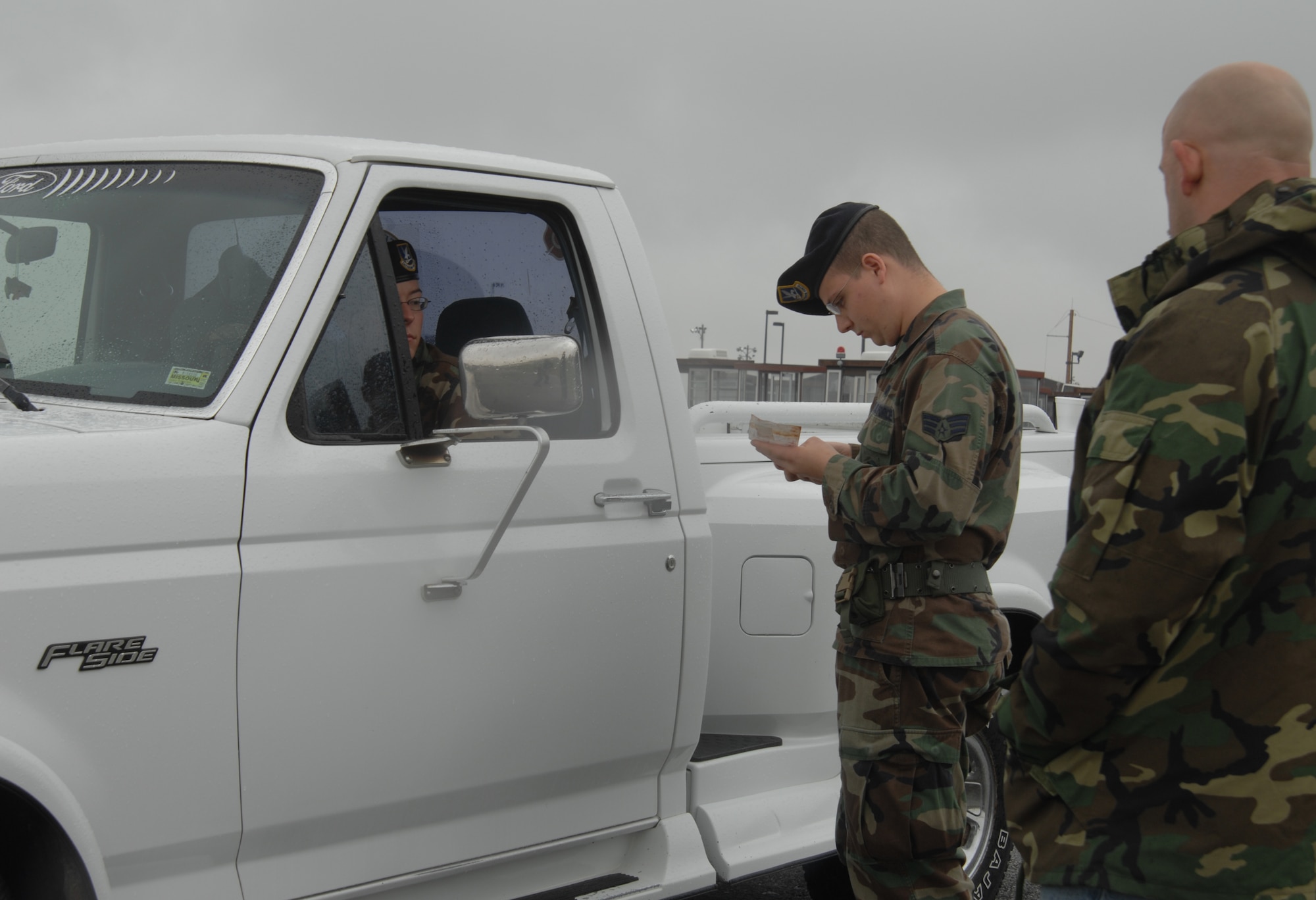WHITEMAN AIR FORCE BASE, Mo. --  Senior Airman Michael Durso, 509th Security Forces Squadron, verifies Airman 1st Class Nathan Staas, 509th SFS, documents, drivers license, military identification, vehicle registration, and proof of insurance while training instructor Billy Matheny, 509th SFS, evaluates the exercise Oct.26. Part of the mission of the 509th SFS is to provide effective law enforcement services to the base population. (U.S. Air Force photo/Airman 1st Class Jessica Snow)