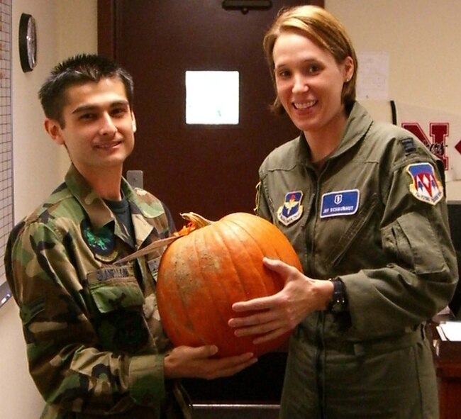 Airman 1st Class Max Gianelloni, 71st Operational Support Squadron, gets a hold of a Halloween pumpkin delivered by Capt. Joy Schaubhut, 71 Medical Operations Squadron. The Vance Company Grade Officers’ Council delivered over 20 pumpkins in October to E-4 and below with children. (U.S. Air Force photo by 1st Lt. Jamie Kaauamo) 