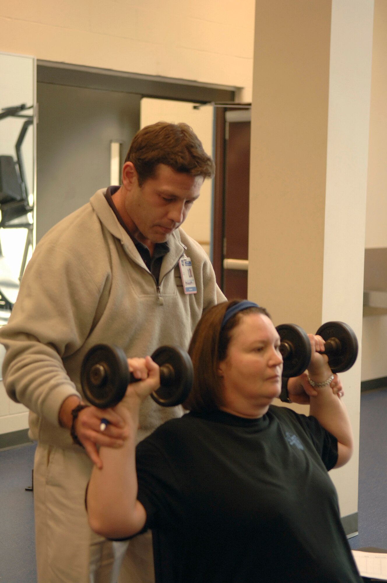 HANSCOM AFB, Mass. -- 66th Medical Group Exercise Physiologist Craig Brickl assists Master Sgt. Renata Sandham, 360th Recruiting Group, with free-weight exercises. Mr. Brickl helps Hanscom personnel determine their physical fitness needs and creates individualized programs to help them achieve their goals. (U.S. Air Force photo by Jan Abate.)

