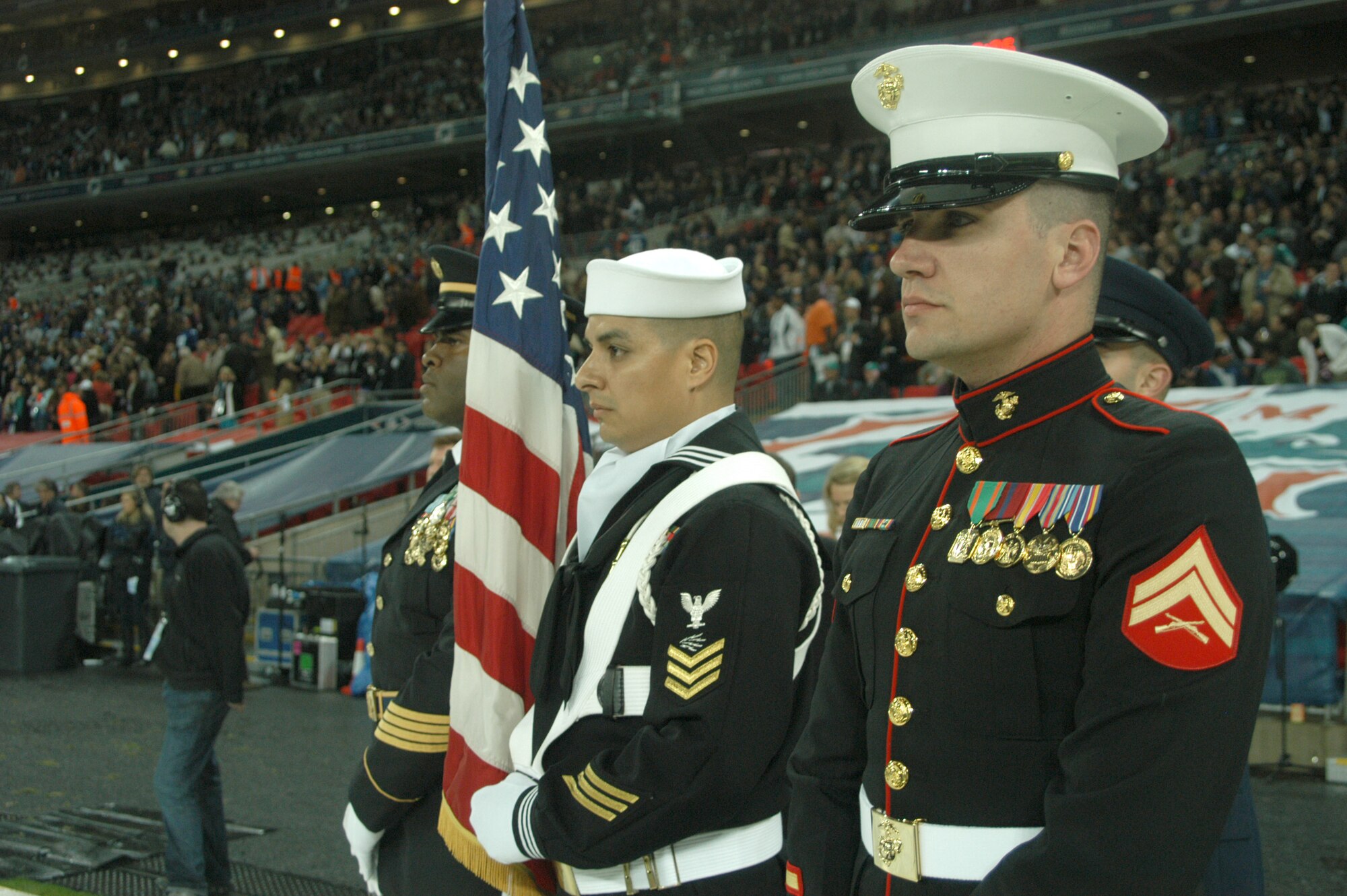 The USEUCOM Joint Analysis Center Honor Guard stands ready to take the field at the October 28 first-ever NFL regular season game outside the United States in London's new 90,000 seat Wembley Stadium. The 4 man detachment joined with a British joint services colour guard for a performance during the playing of "God Save The Queen," and "The Star Spangled Banner" at the opening of the game.  (USAF Photo by Staff Sgt. Jocelyn L. Rich)